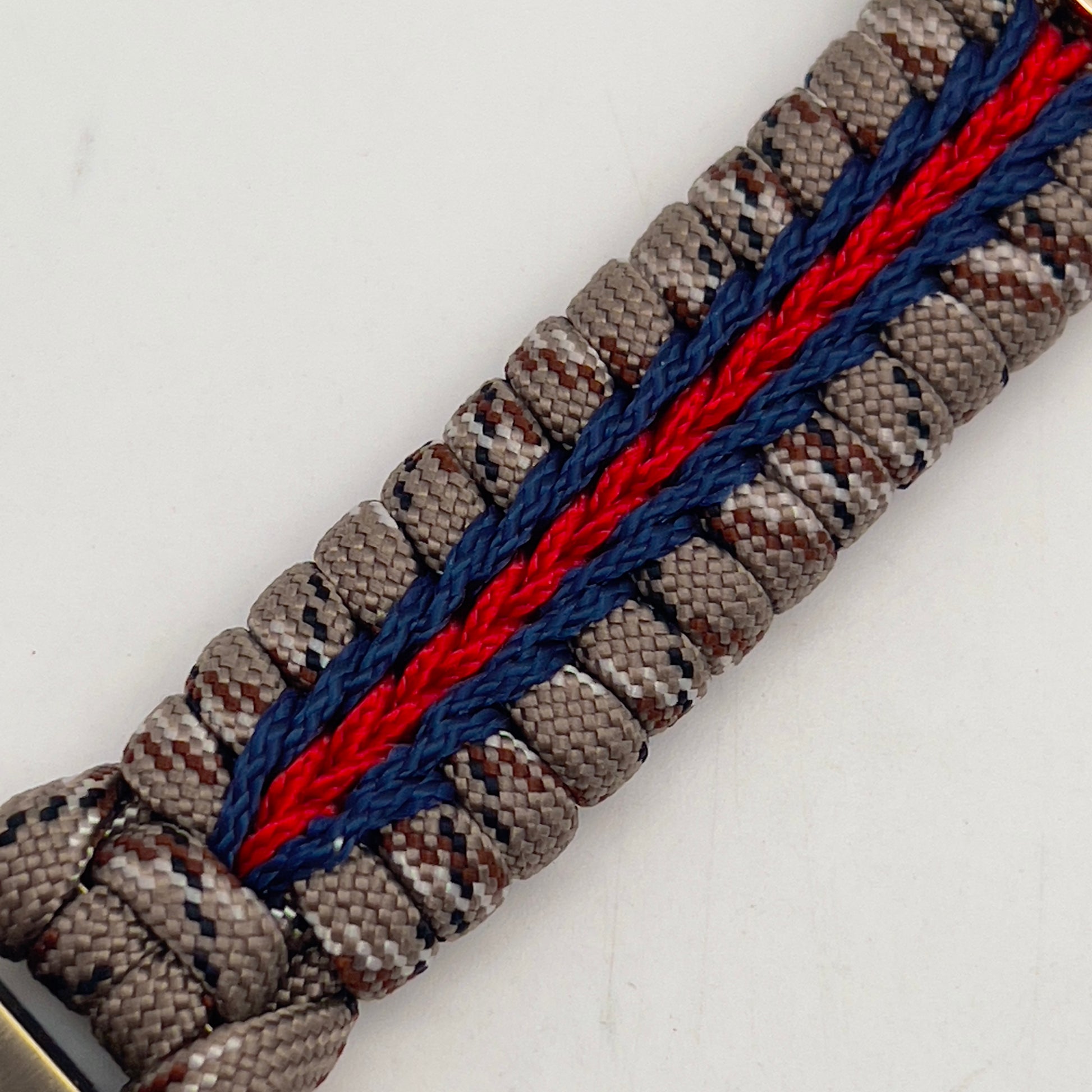 Thick and comfortable braided United States Marine Corps bracelet featuring a 24K gold and silver plated USMC officer Eagle Globe and Anchor medallion, a Cobra style tactical buckle and woven with Desert Camo 550 paracord and Imperial red and Navy Blue micro cord.