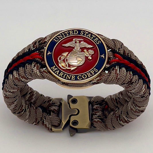 Thick and comfortable braided United States Marine Corps bracelet featuring a 24K gold and silver plated USMC officer Eagle Globe and Anchor medallion, a Cobra style tactical buckle and woven with Desert Camo 550 paracord and Imperial red and black micro cord.