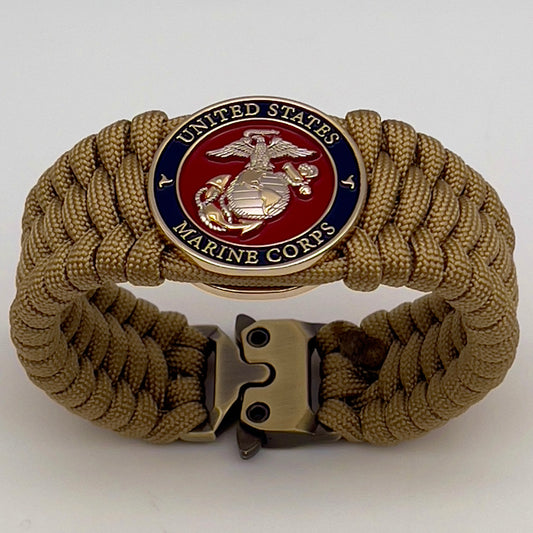Thick and comfortable braided United States Marine Corps bracelet featuring a 24K gold and silver plated USMC officer Eagle Globe and Anchor medallion, a Cobra style tactical buckle and woven with gold 550 paracord.