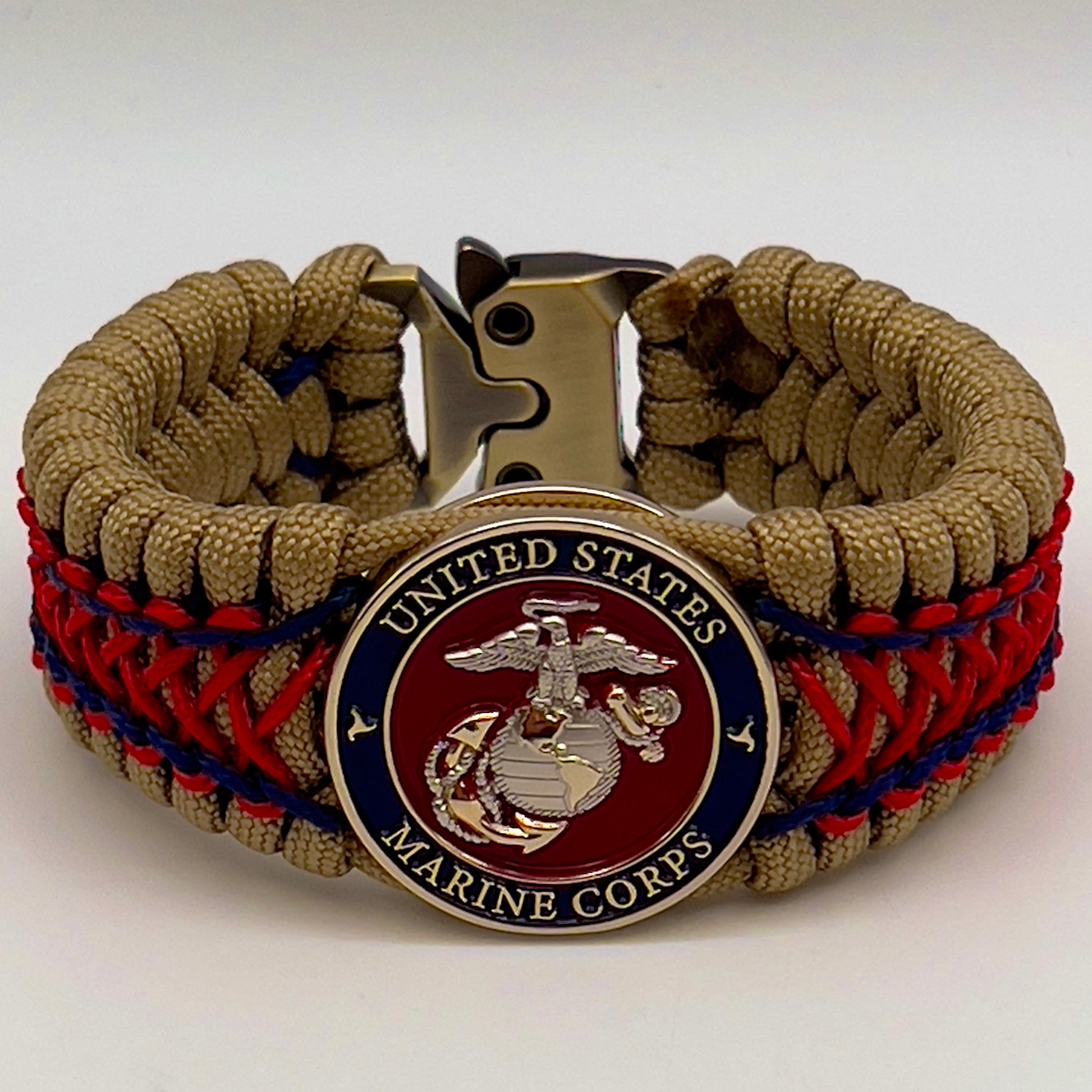 Thick and comfortable braided United States Marine Corps bracelet featuring a 24K gold and silver plated USMC officer Eagle Globe and Anchor medallion, a gold Cobra style tactical buckle and woven with gold 550 paracord and Imperial Red and Navy Blue micro cord.
