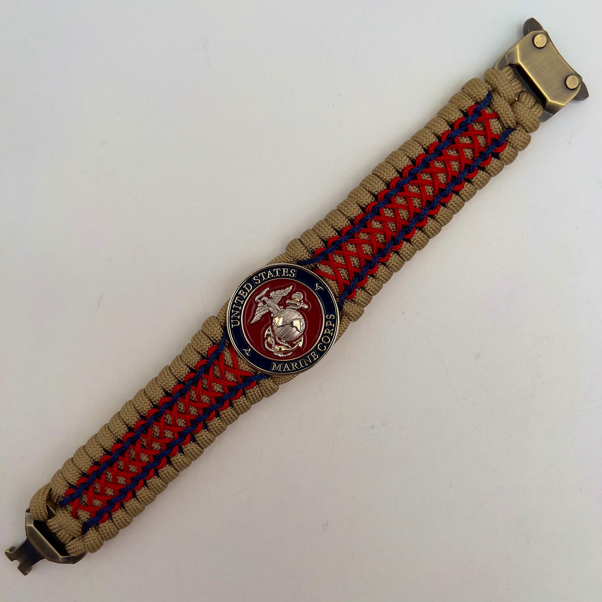 Thick and comfortable braided United States Marine Corps bracelet featuring a 24K gold and silver plated USMC officer Eagle Globe and Anchor medallion, a gold Cobra style tactical buckle and woven with gold 550 paracord and Imperial Red and Navy Blue micro cord.