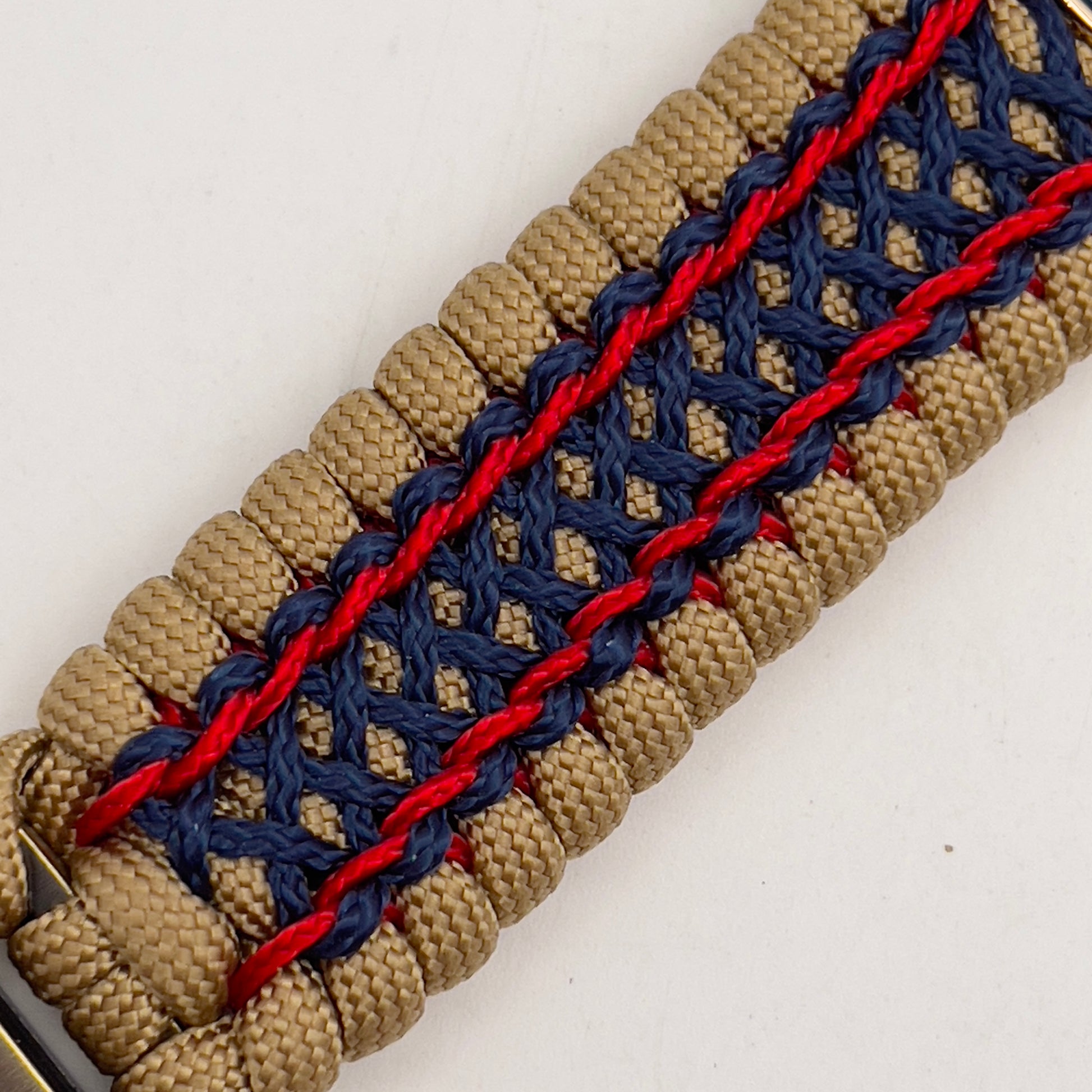 Thick and comfortable braided United States Marine Corps bracelet featuring a 24K gold and silver plated USMC officer Eagle Globe and Anchor medallion, a gold Cobra style tactical buckle and woven with gold 550 paracord and Imperial Red and Navy Blue micro cord.