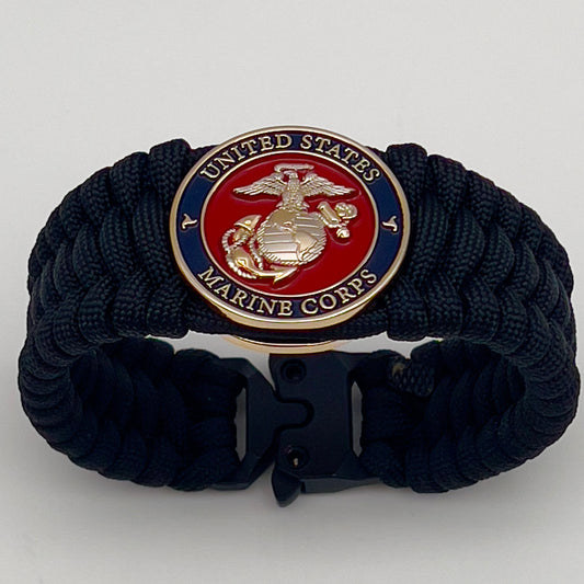 Thick and comfortable braided United States Marine Corps bracelet featuring a 24K gold and silver plated USMC officer Eagle Globe and Anchor medallion, a black Cobra style tactical buckle and woven with black 550 paracord.