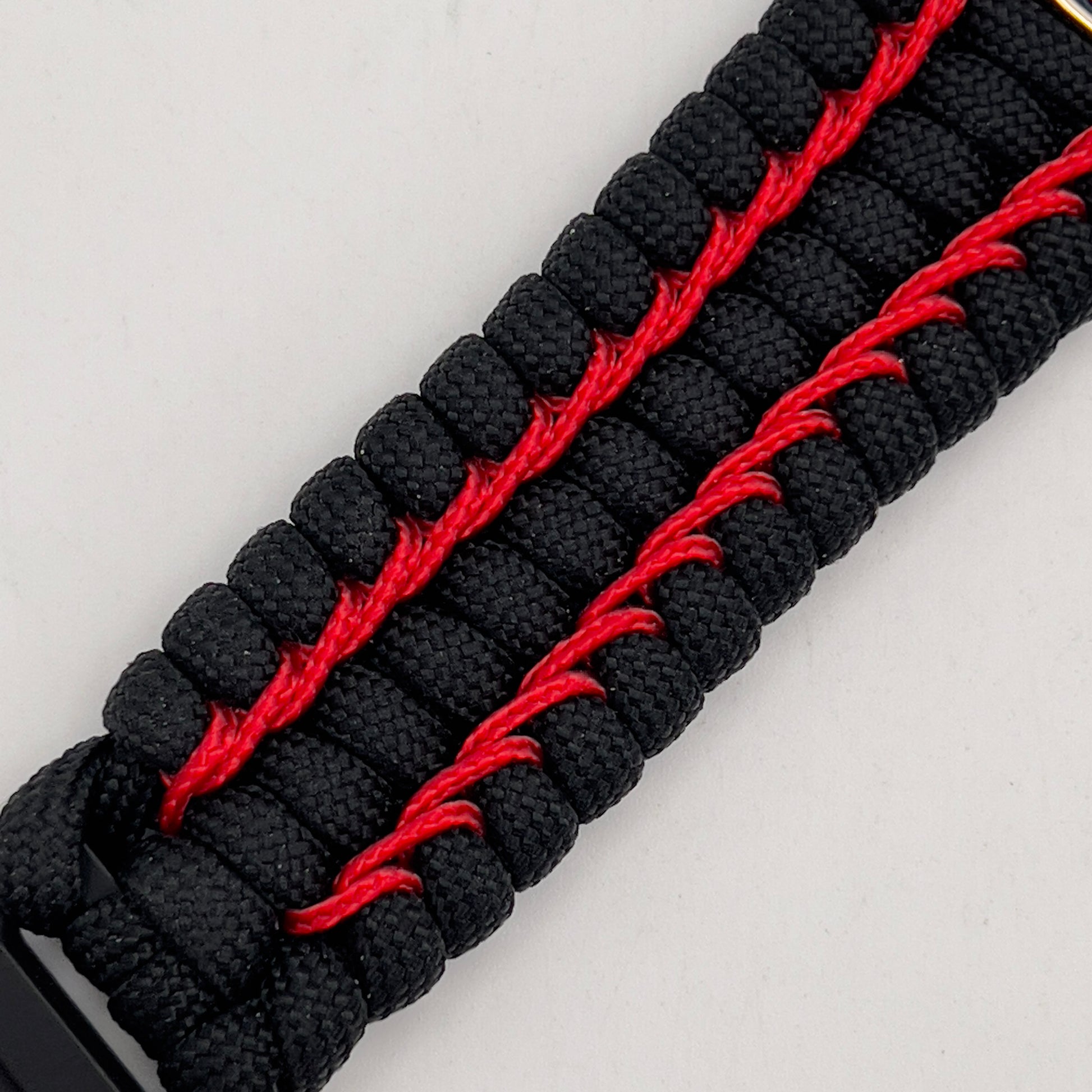 Thick and comfortable braided United States Marine Corps bracelet featuring a 24K gold and silver plated USMC officer Eagle Globe and Anchor medallion, a black Cobra style tactical buckle and woven with black 550 paracord and Imperial Red micro cord.