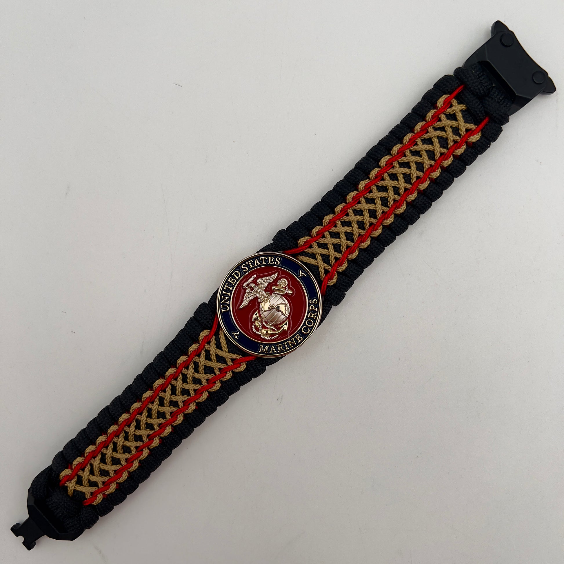Thick and comfortable braided United States Marine Corps bracelet featuring a 24K gold and silver plated USMC officer Eagle Globe and Anchor medallion, a black Cobra style tactical buckle and woven with black 550 paracord and Imperial Red and gold micro cord.