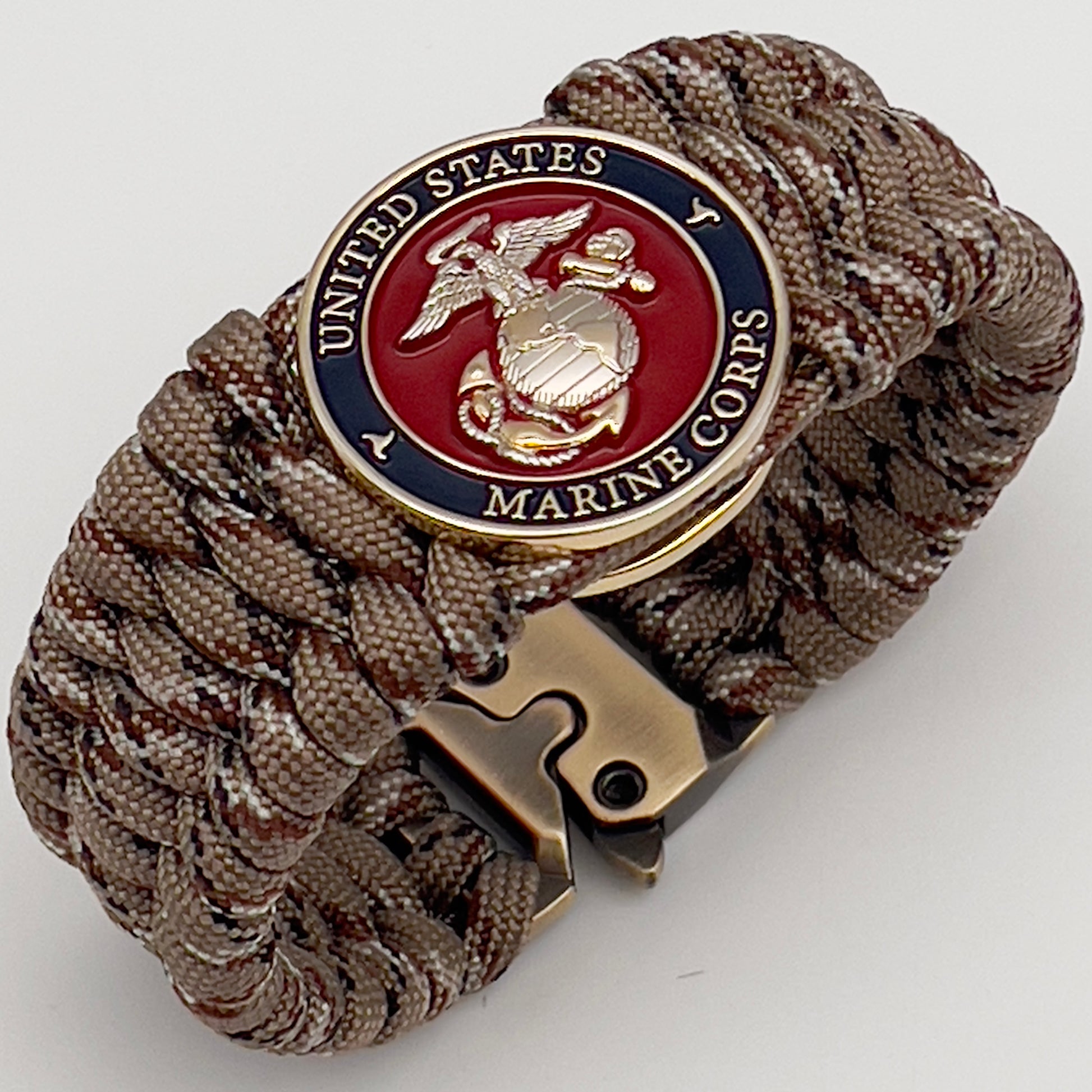 Thick and comfortable braided United States Marine Corps bracelet featuring a 24K gold and silver plated USMC officer Eagle Globe and Anchor medallion, a gold Cobra style tactical buckle and woven with Desert Camo 550 paracord.