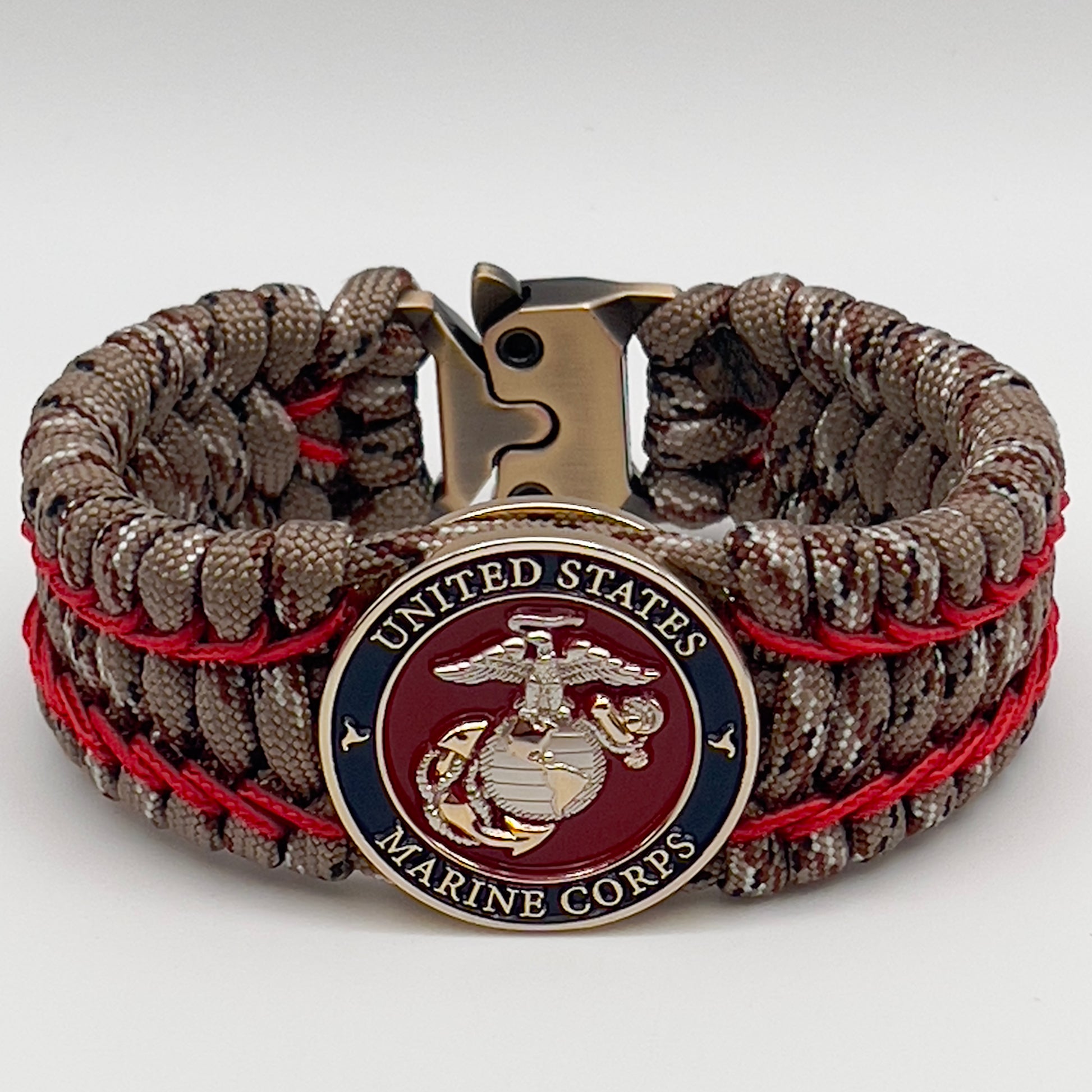 Thick and comfortable braided United States Marine Corps bracelet featuring a 24K gold and silver plated USMC officer Eagle Globe and Anchor medallion, a gold Cobra style tactical buckle and woven with Desert Camo 550 paracord and Imperial Red micro cord.
