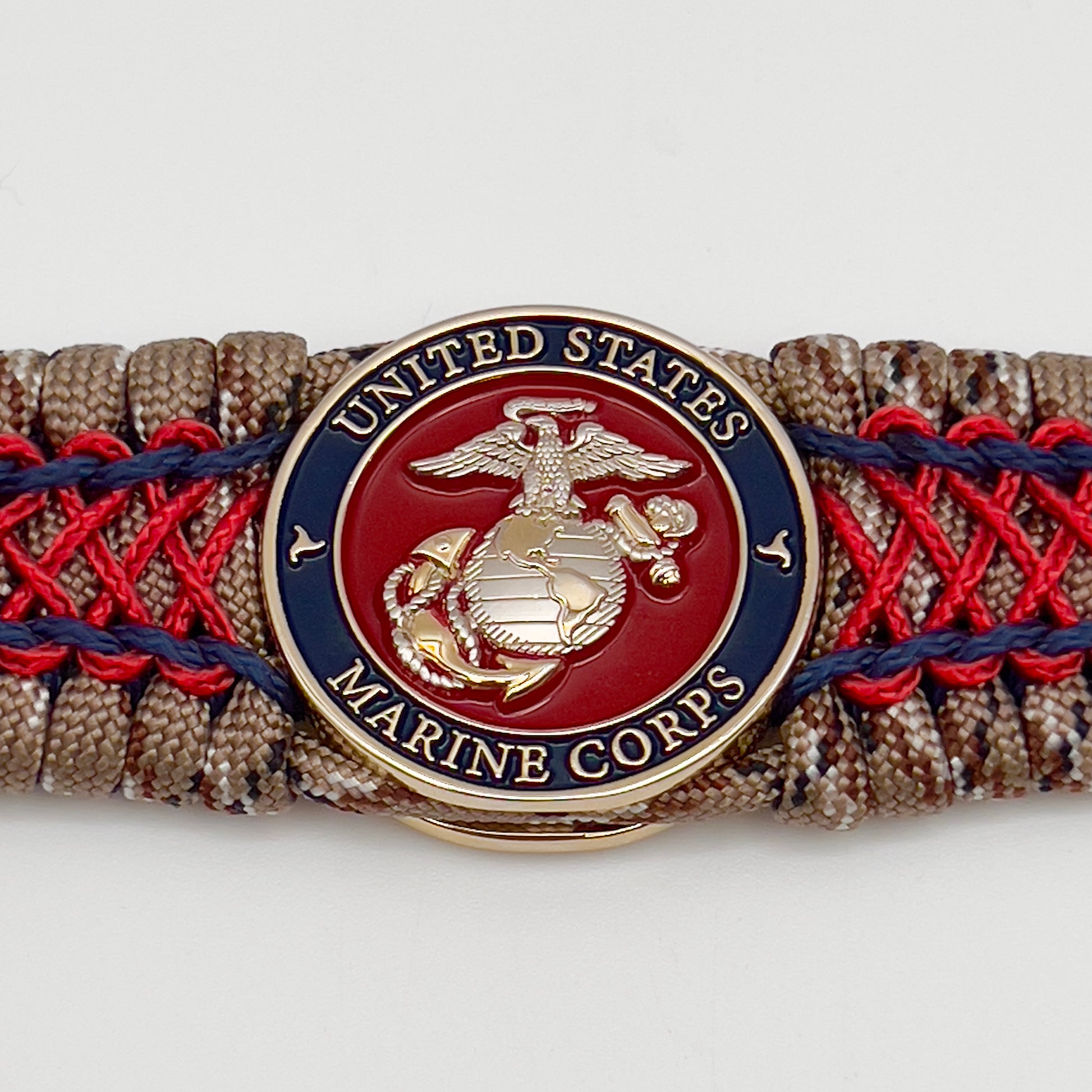 Thick and comfortable braided United States Marine Corps bracelet featuring a 24K gold and silver plated USMC officer Eagle Globe and Anchor medallion, a gold Cobra style tactical buckle and woven with Desert Camo 550 paracord and Imperial Red and Navy Blue micro cord.