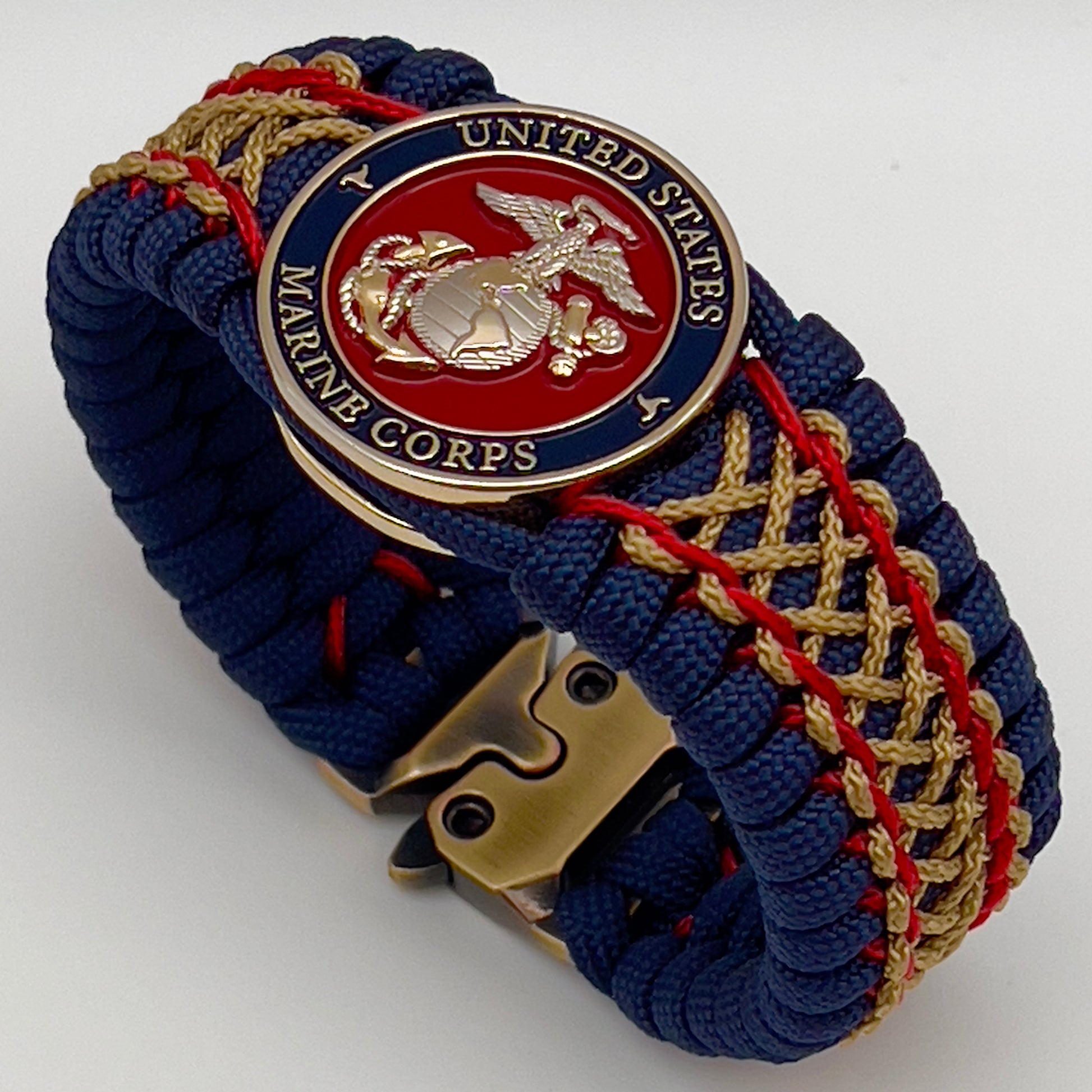Thick and comfortable braided United States Marine Corps bracelet featuring a 24K gold and silver plated USMC officer Eagle Globe and Anchor medallion, a Cobra style tactical buckle and woven with gold 550 paracord and Imperial Red and Gold micro cord.
