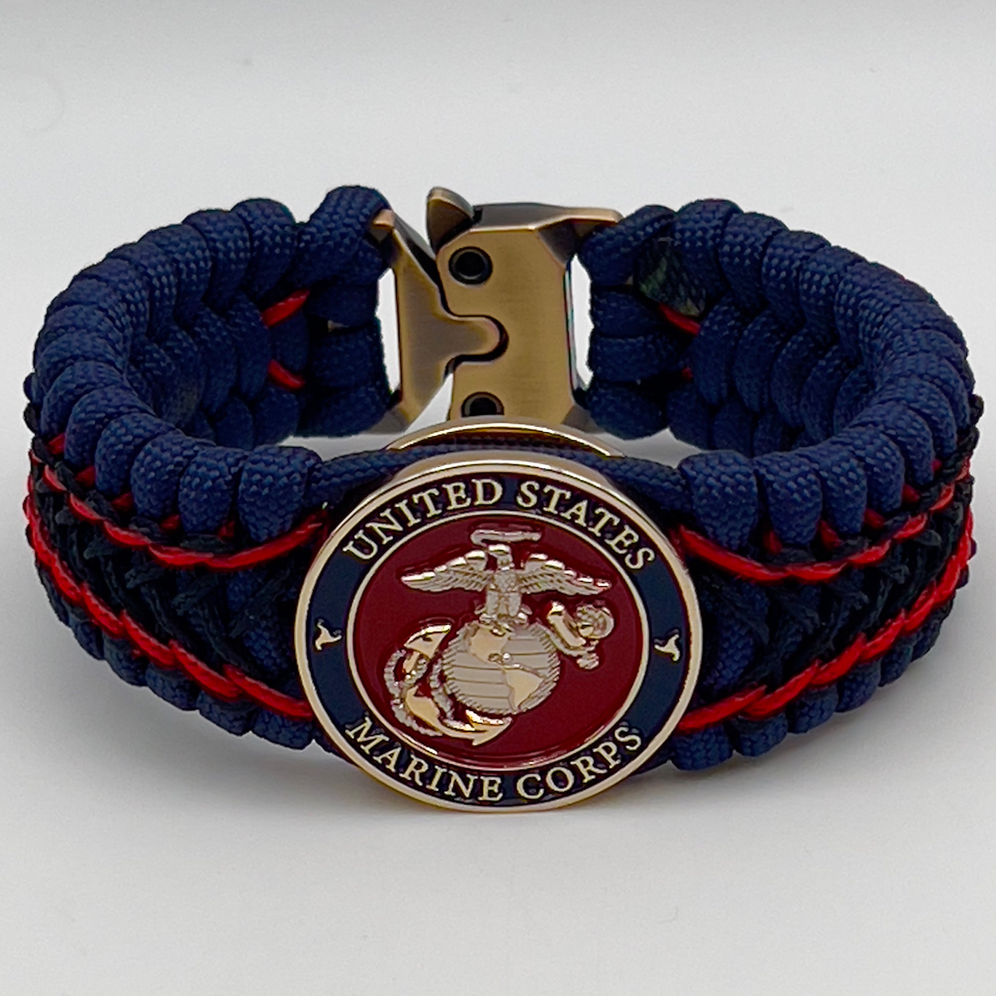 Thick and comfortable braided United States Marine Corps bracelet featuring a 24K gold and silver plated USMC officer Eagle Globe and Anchor medallion, a Cobra style tactical buckle and woven with gold 550 paracord and Imperial Red and Black micro cord.