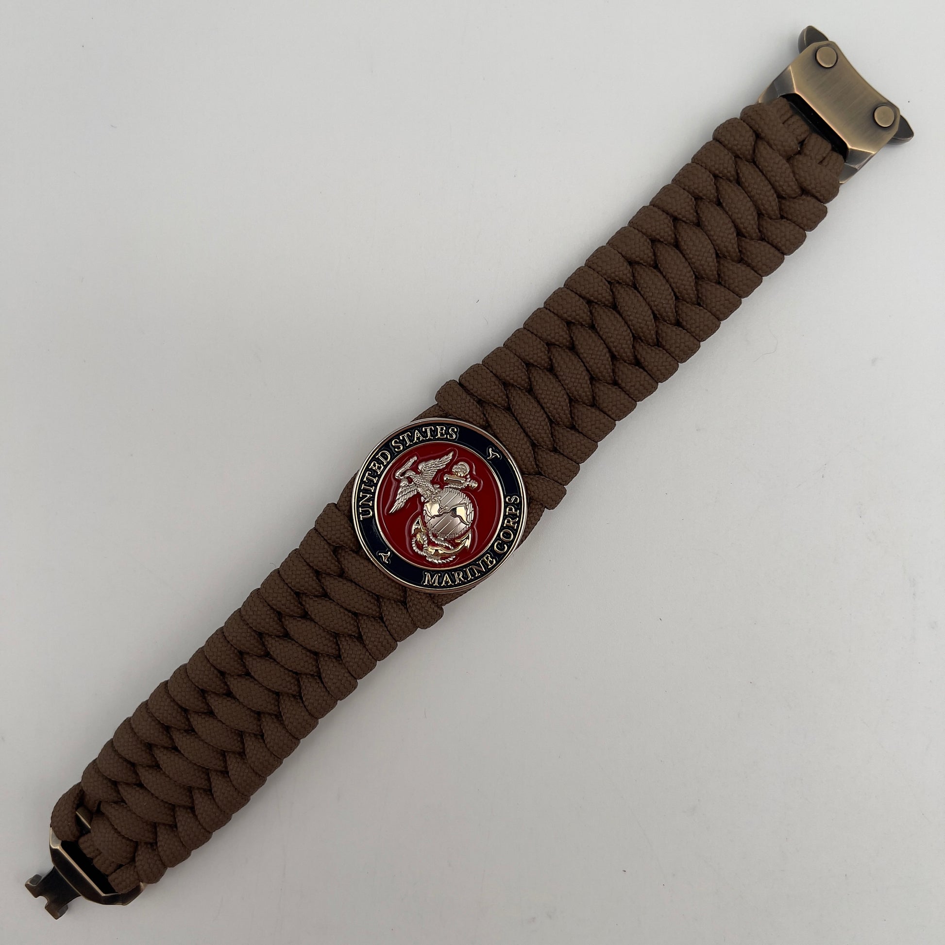 Thick and comfortable braided United States Marine Corps bracelet featuring a 24K gold and silver plated USMC officer Eagle Globe and Anchor medallion, a Cobra style tactical buckle and woven with Coyote Brown 550 paracord.