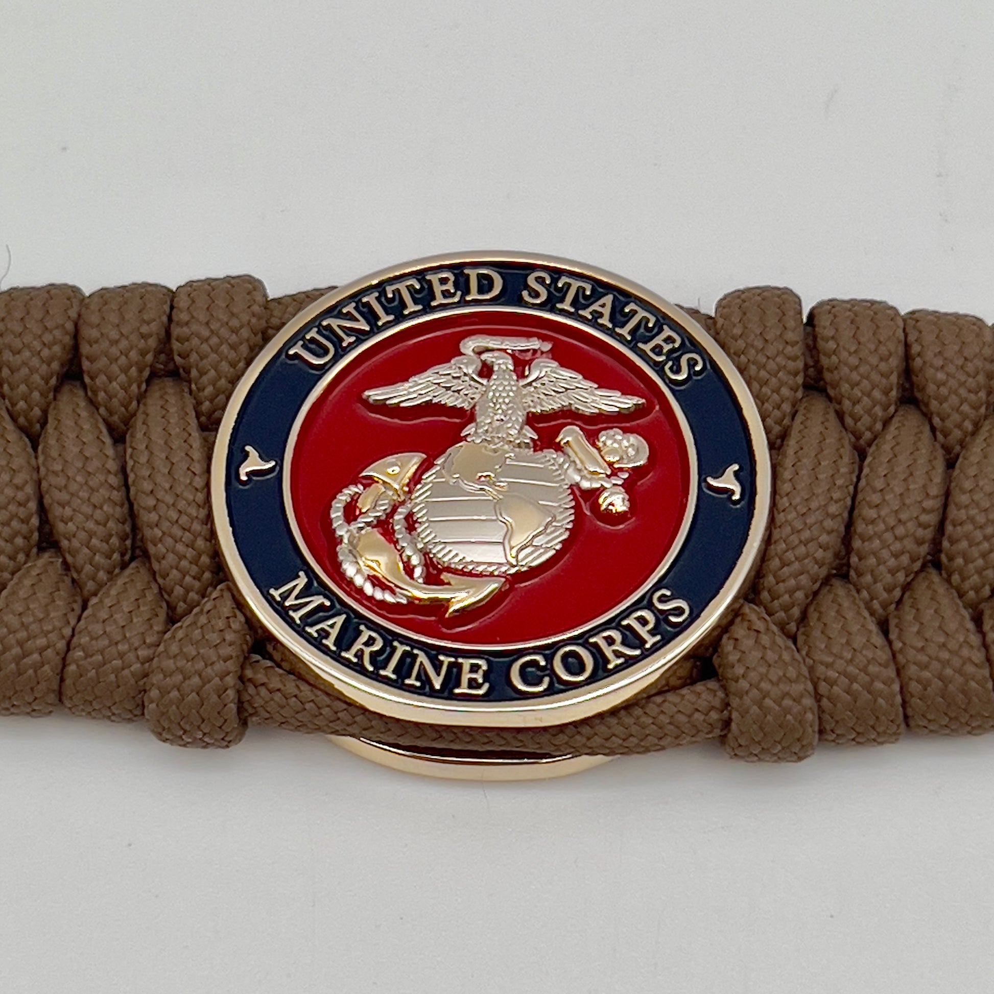 Thick and comfortable braided United States Marine Corps bracelet featuring a 24K gold and silver plated USMC officer Eagle Globe and Anchor medallion, a Cobra style tactical buckle and woven with Coyote Brown 550 paracord.