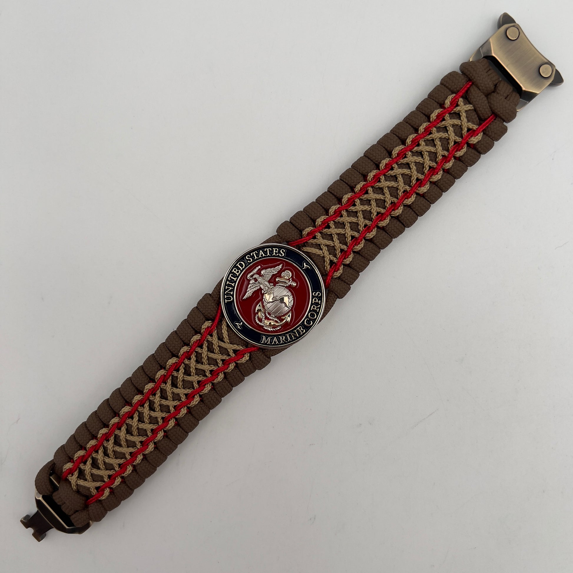 Thick and comfortable braided United States Marine Corps bracelet featuring a 24K gold and silver plated USMC officer Eagle Globe and Anchor medallion, a Cobra style tactical buckle and woven with Coyote Brown 550 paracord and Imperial Red and gold micro cord.