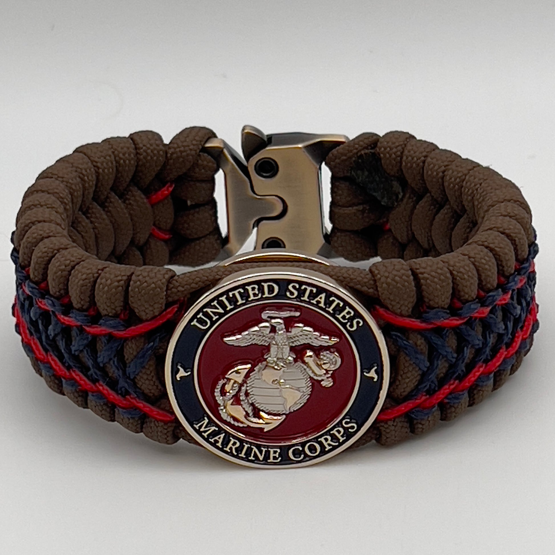 Thick and comfortable braided United States Marine Corps bracelet featuring a 24K gold and silver plated USMC officer Eagle Globe and Anchor medallion, a Cobra style tactical buckle and woven with Coyote Brown 550 paracord and Imperial Red and Navy Blue micro cord.