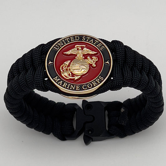 Thick, semi-rigid and comfortable braided United States Marine Corps bracelet featuring a 24K gold plated USMC officer Eagle Globe and Anchor medallion, a black Cobra style tactical buckle and woven with black 550 paracord.
