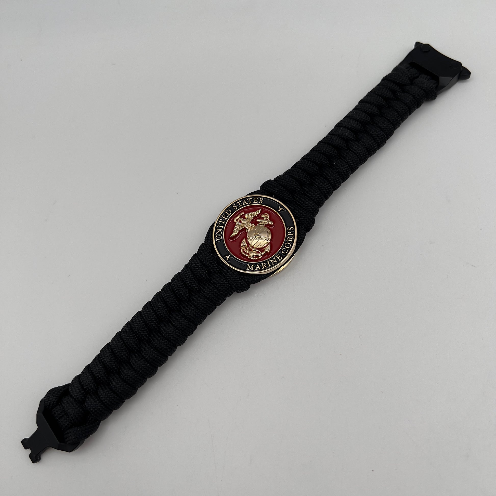 Thick, semi-rigid and comfortable braided United States Marine Corps bracelet featuring a 24K gold plated USMC officer Eagle Globe and Anchor medallion, a black Cobra style tactical buckle and woven with black 550 paracord.