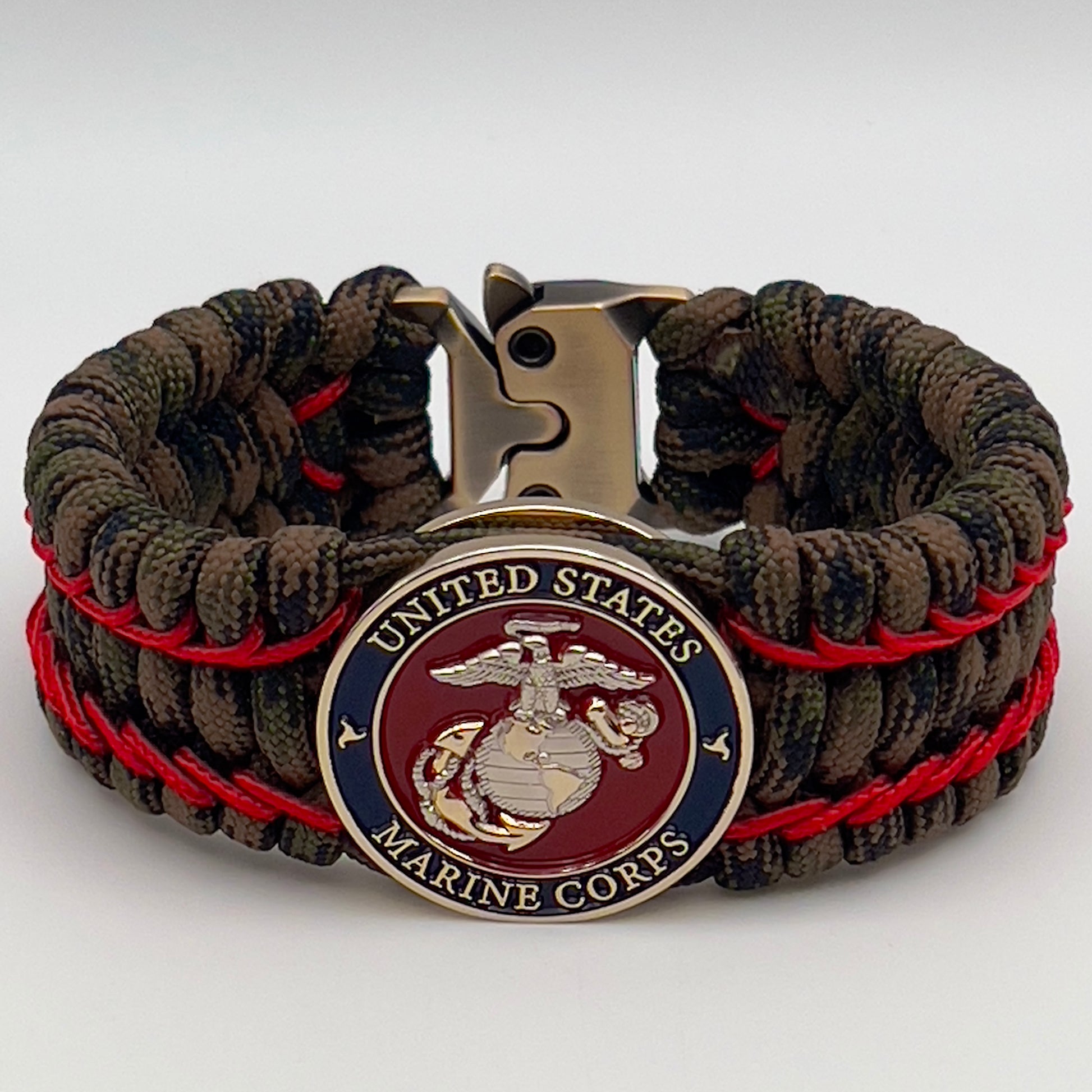 Thick, rigid and comfortable braided United States Marine Corps bracelet featuring a 24K gold and silver plated USMC officer Eagle Globe and Anchor medallion, a gold Cobra style tactical buckle and woven with Woodland Camo 550 paracord and Imperial Red micro cord.