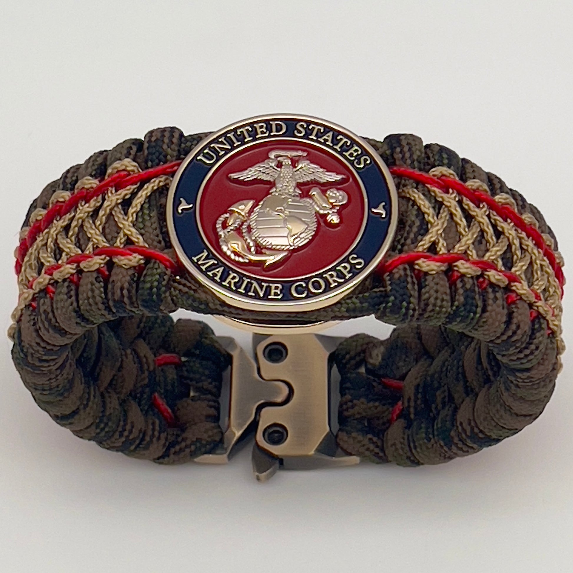 Thick, rigid and comfortable braided United States Marine Corps bracelet featuring a 24K gold and silver plated USMC officer Eagle Globe and Anchor medallion, a gold Cobra style tactical buckle and woven with Woodland Camo 550 paracord and Imperial Red and gold micro cord.