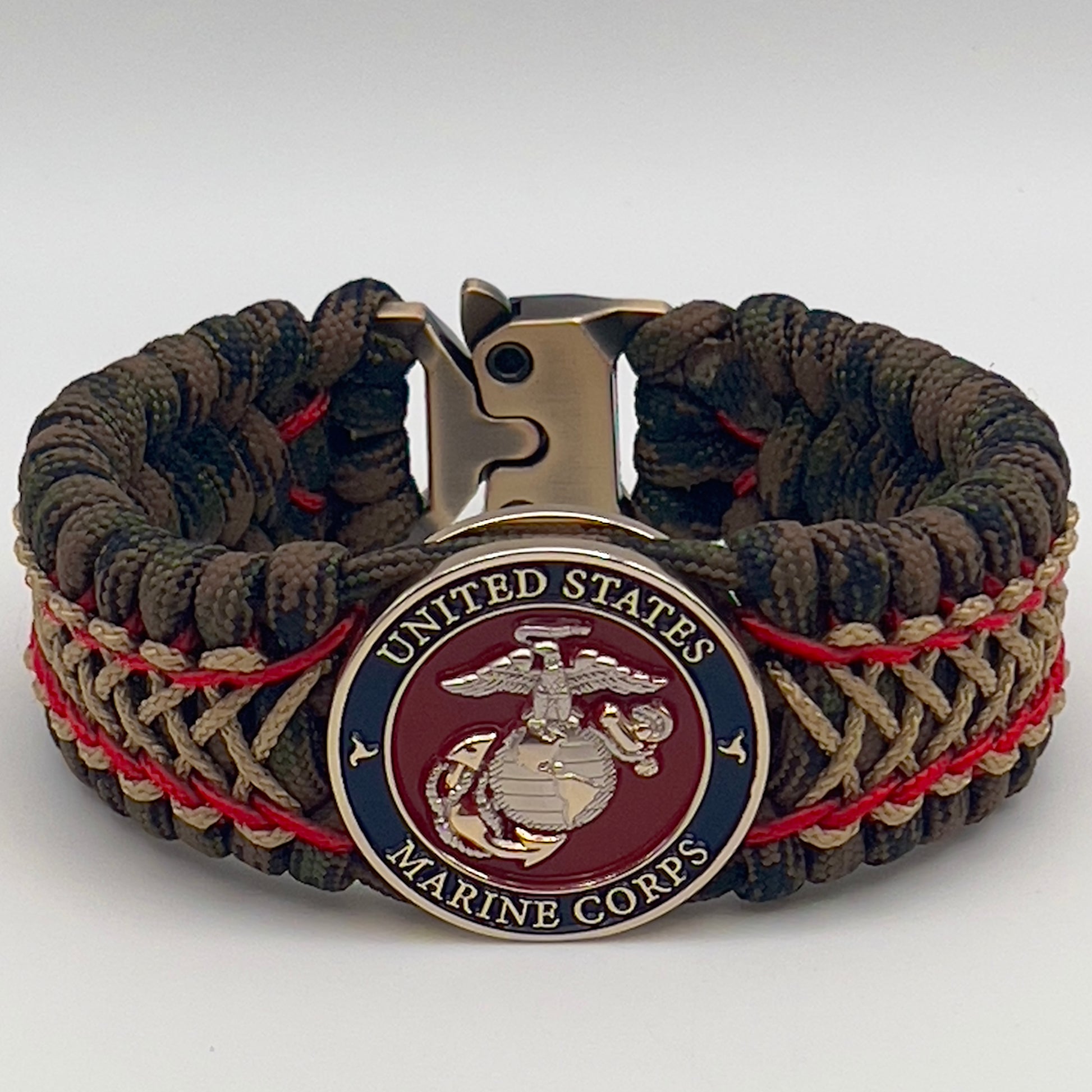 Thick, rigid and comfortable braided United States Marine Corps bracelet featuring a 24K gold and silver plated USMC officer Eagle Globe and Anchor medallion, a gold Cobra style tactical buckle and woven with Woodland Camo 550 paracord and Imperial Red and gold micro cord.