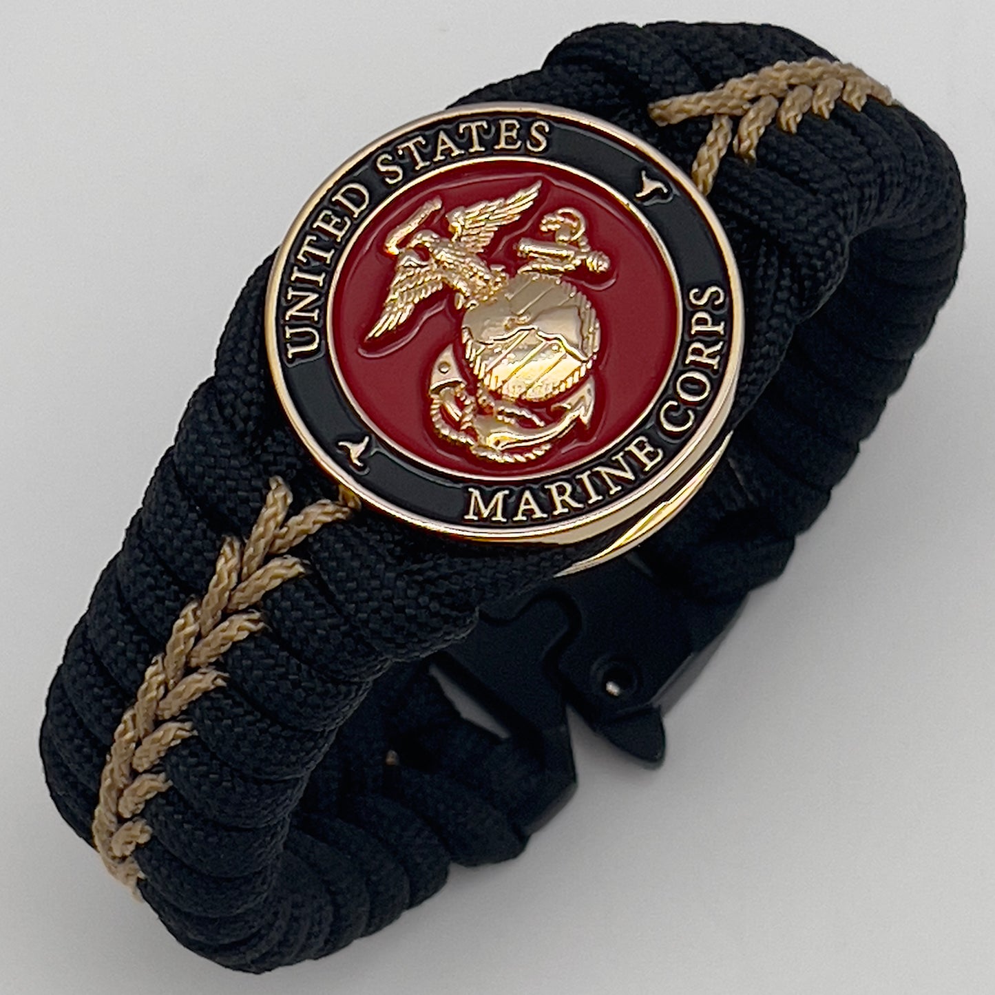 Thick, semi-rigid and comfortable braided United States Marine Corps bracelet featuring a 24K gold plated USMC officer Eagle Globe and Anchor medallion, a black Cobra style tactical buckle and woven with black 550 paracord and gold micro cord.