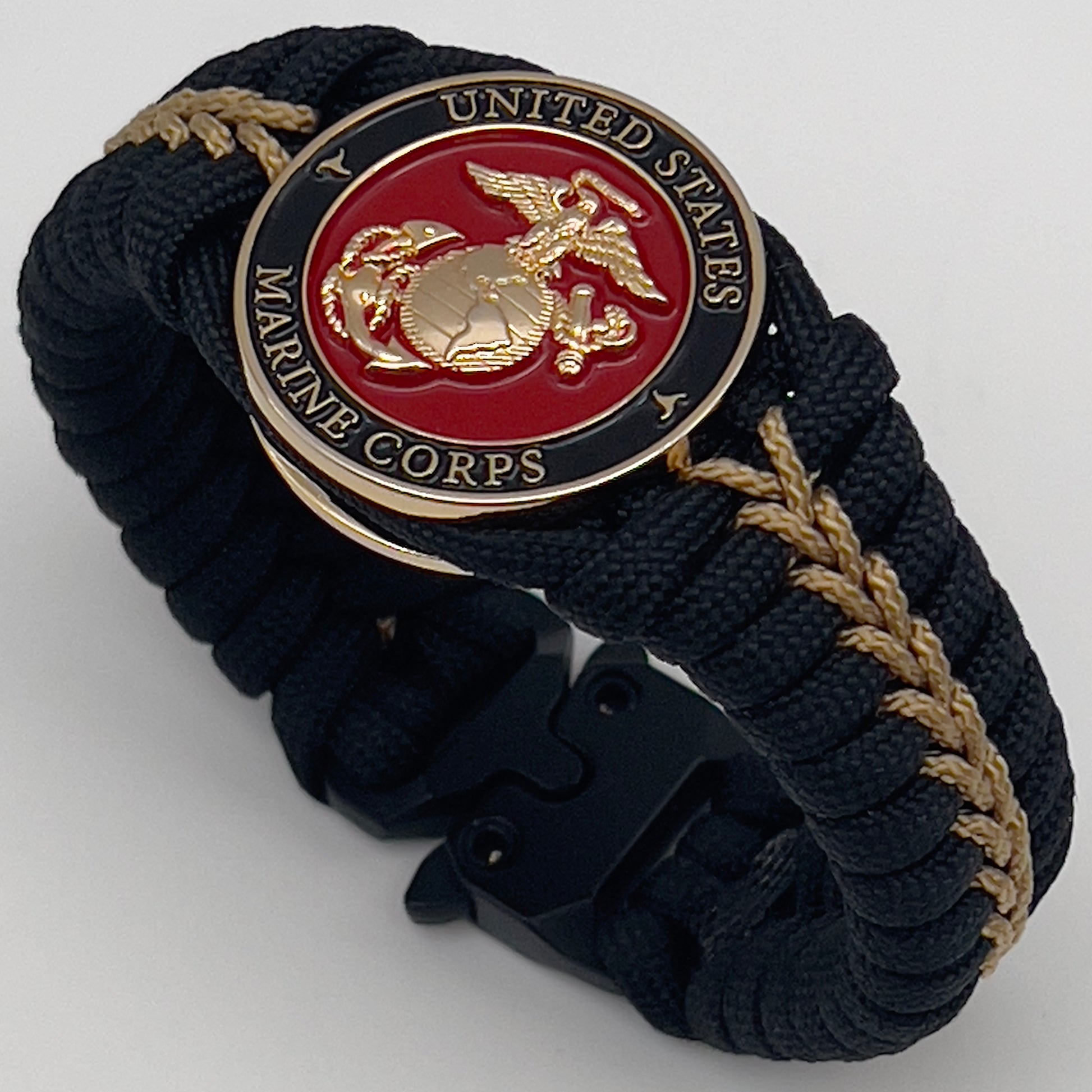 Thick, semi-rigid and comfortable braided United States Marine Corps bracelet featuring a 24K gold plated USMC officer Eagle Globe and Anchor medallion, a black Cobra style tactical buckle and woven with black 550 paracord and gold micro cord.