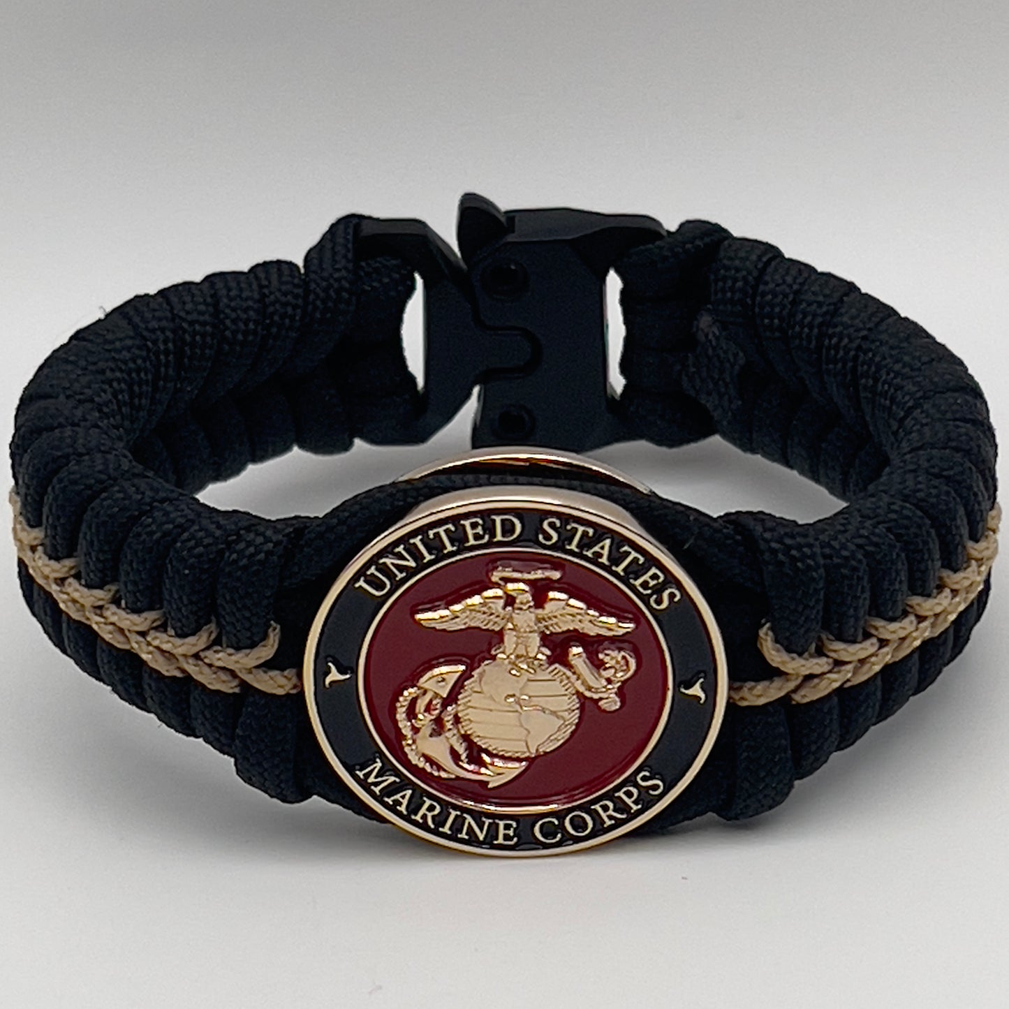 Thick, semi-rigid and comfortable braided United States Marine Corps bracelet featuring a 24K gold plated USMC officer Eagle Globe and Anchor medallion, a black Cobra style tactical buckle and woven with black 550 paracord and gold micro cord.