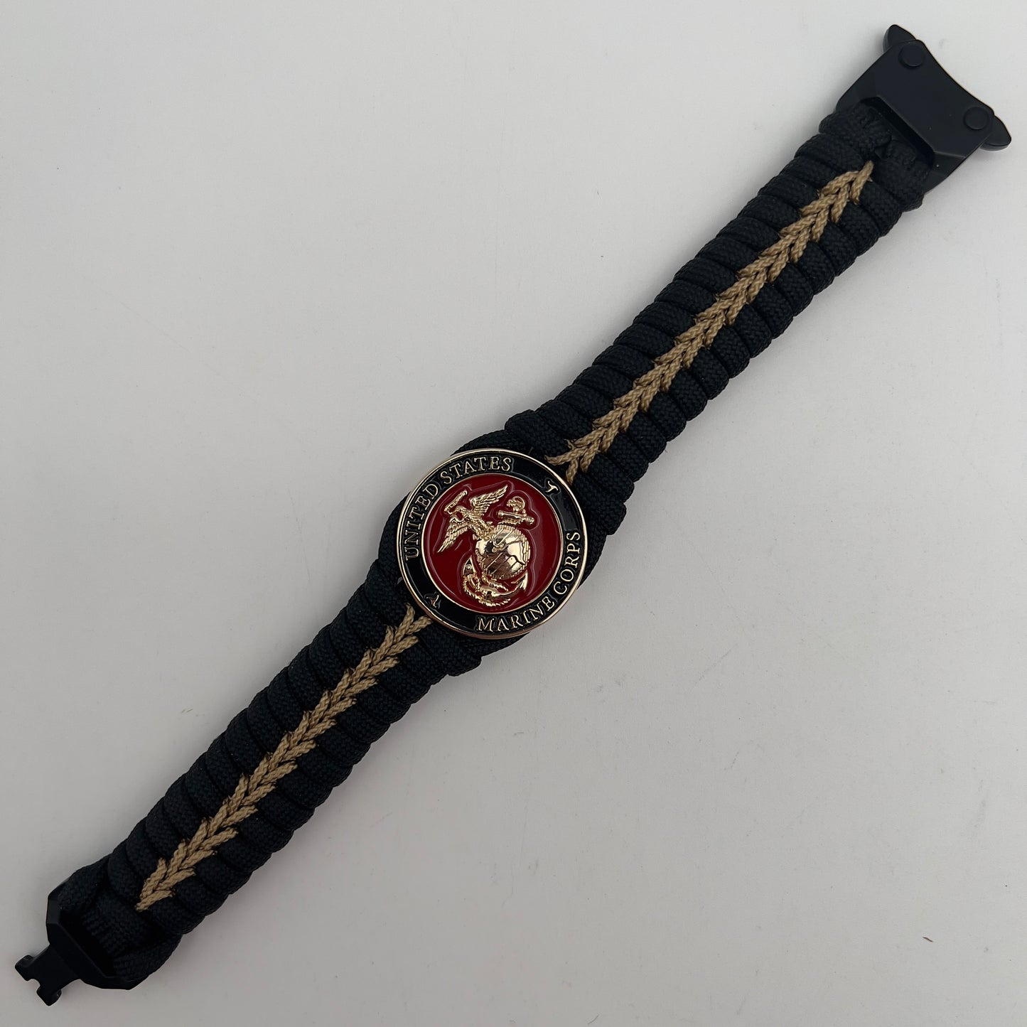 Thick, semi-rigid and comfortable braided United States Marine Corps bracelet featuring a 24K gold plated USMC officer Eagle Globe and Anchor medallion, a black Cobra style tactical buckle and woven with black 550 paracord and gold micro cord.