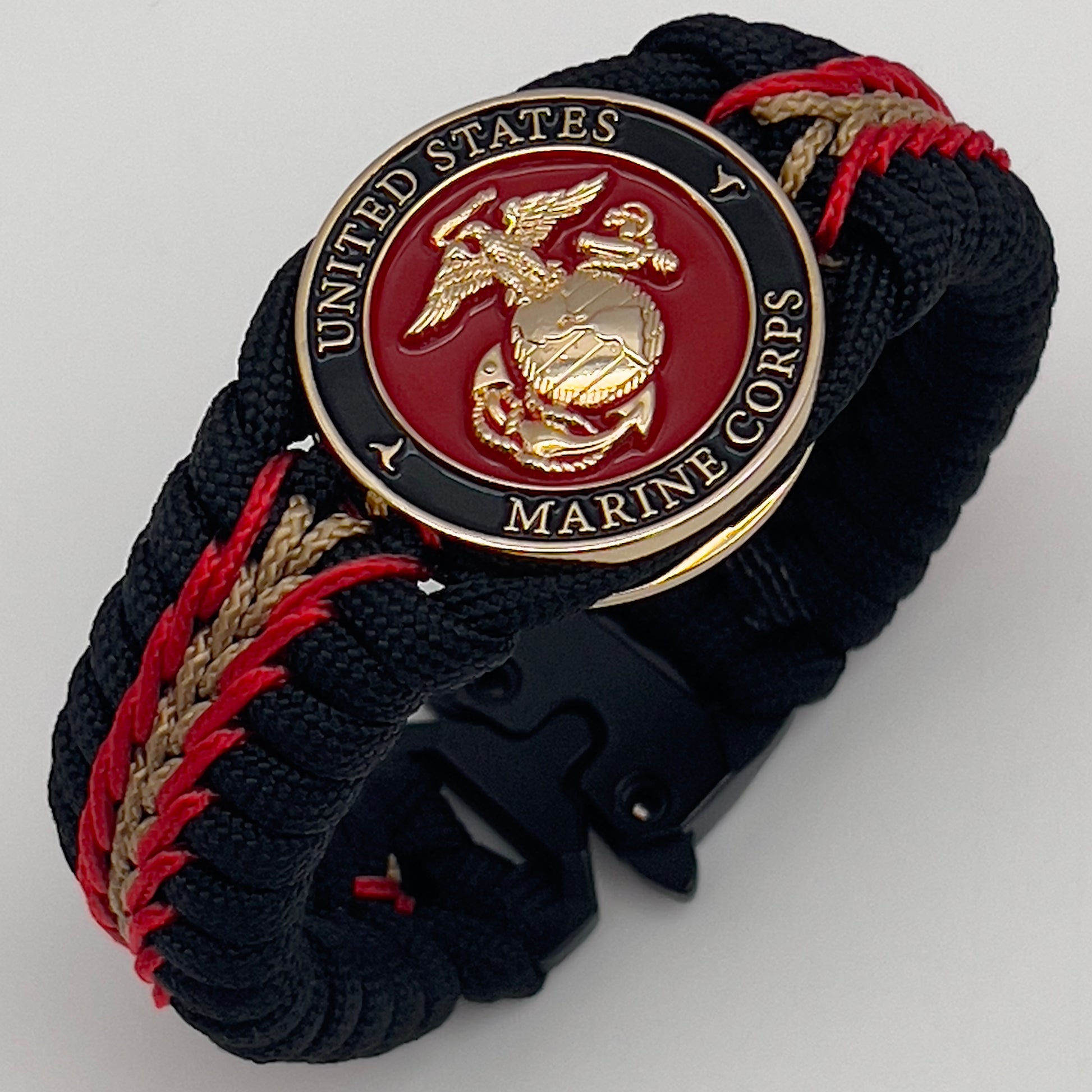 Thick, semi-rigid and comfortable braided United States Marine Corps bracelet featuring a 24K gold and silver plated USMC officer Eagle Globe and Anchor medallion, a black Cobra style tactical buckle and woven with black 550, Imperial red and gold micro paracord.