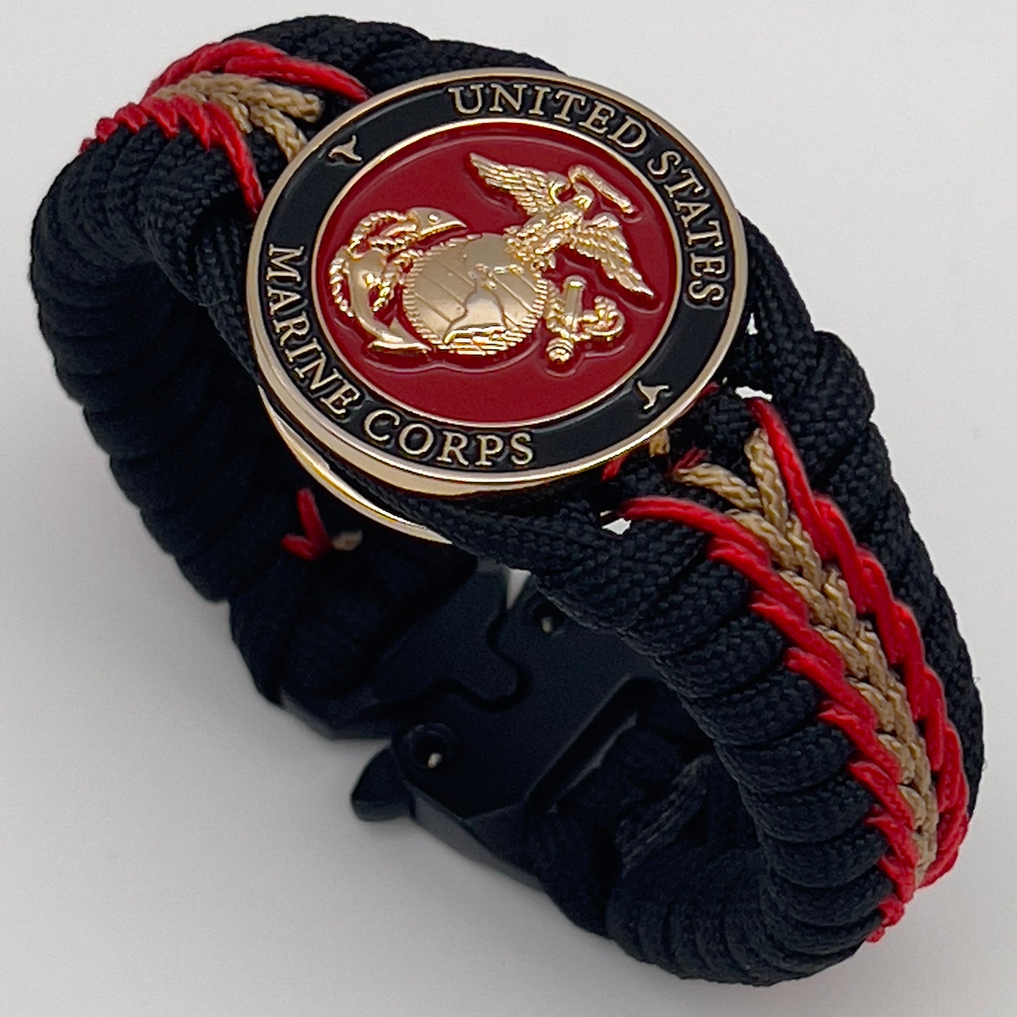 Thick, semi-rigid and comfortable braided United States Marine Corps bracelet featuring a 24K gold and silver plated USMC officer Eagle Globe and Anchor medallion, a black Cobra style tactical buckle and woven with black 550, Imperial red and gold micro paracord.