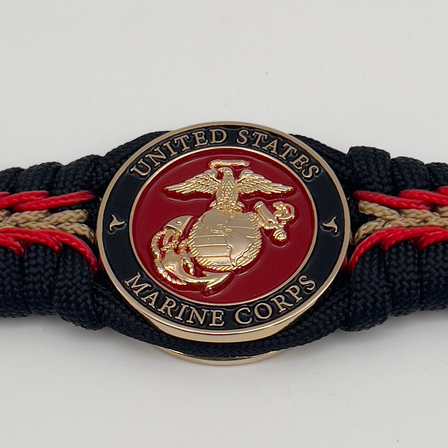Thick, semi-rigid and comfortable braided United States Marine Corps bracelet featuring a 24K gold and silver plated USMC officer Eagle Globe and Anchor medallion, a black Cobra style tactical buckle and woven with black 550, Imperial red and gold micro paracord.