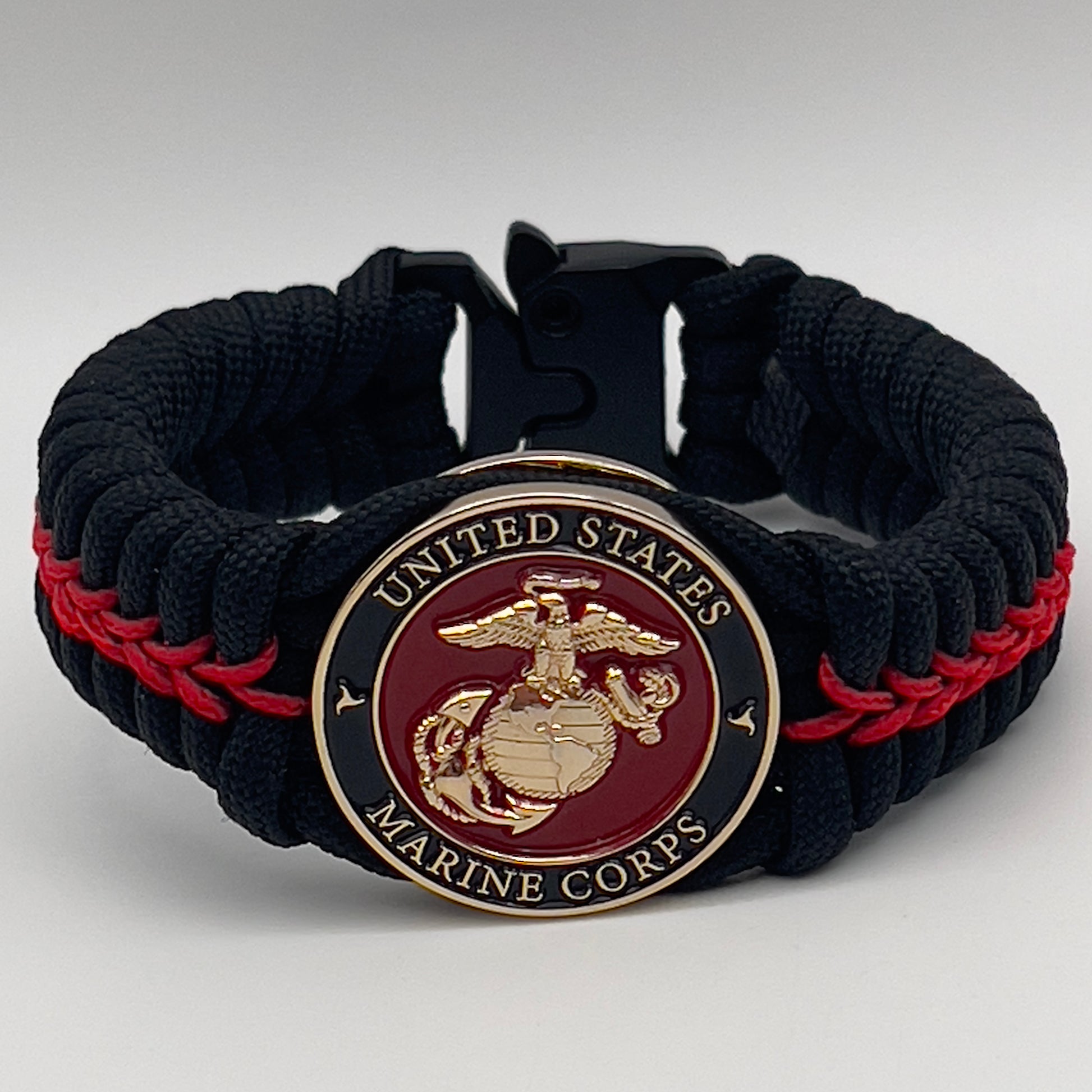 Thick, semi-rigid and comfortable braided United States Marine Corps bracelet featuring a 24K gold plated USMC officer Eagle Globe and Anchor medallion, a black Cobra style tactical buckle and woven with black 550 paracord and Imperial Red micro cord.