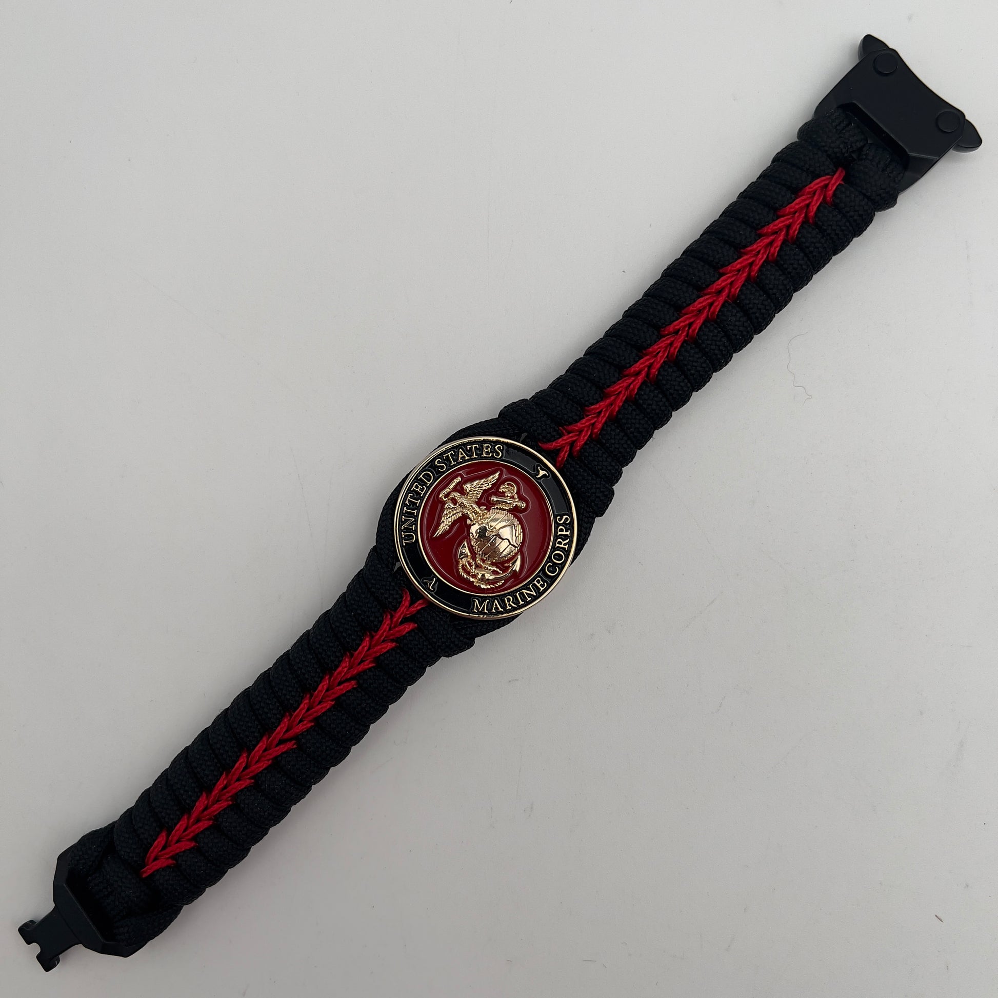 Thick, semi-rigid and comfortable braided United States Marine Corps bracelet featuring a 24K gold plated USMC officer Eagle Globe and Anchor medallion, a black Cobra style tactical buckle and woven with black 550 paracord and Imperial Red micro cord.