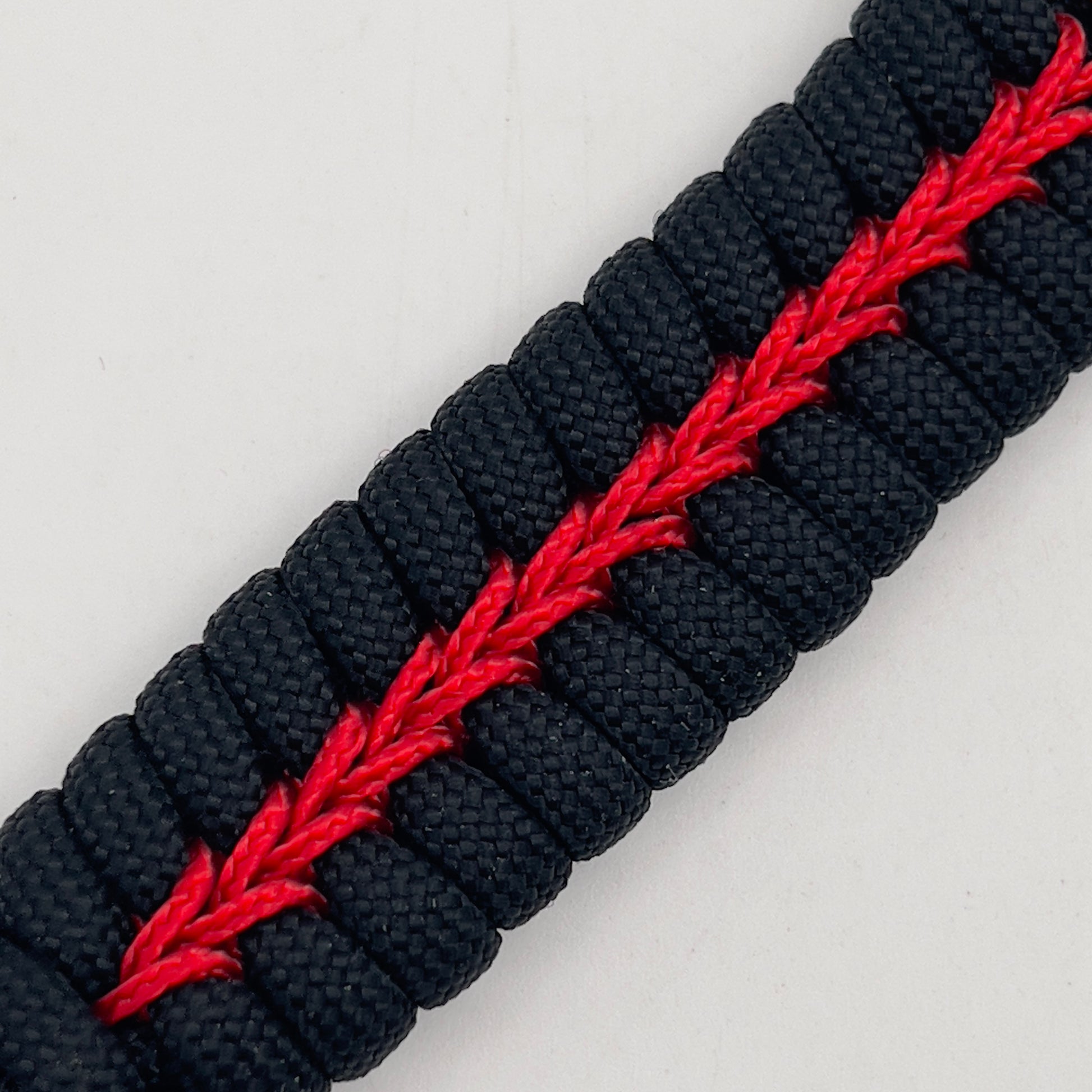 Thick, semi-rigid and comfortable braided United States Marine Corps bracelet featuring a 24K gold plated USMC officer Eagle Globe and Anchor medallion, a black Cobra style tactical buckle and woven with black 550 paracord and Imperial Red micro cord.