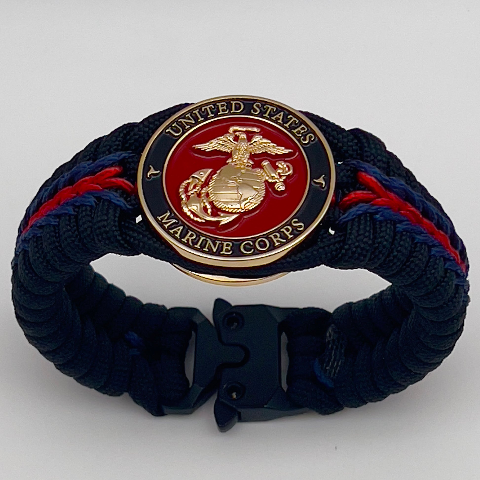 Thick, rigid and comfortable braided United States Marine Corps bracelet featuring a 24K gold plated USMC officer Eagle Globe and Anchor medallion, a black Cobra style tactical buckle and woven with black 550, Imperial red and Navy Blue micro paracord.