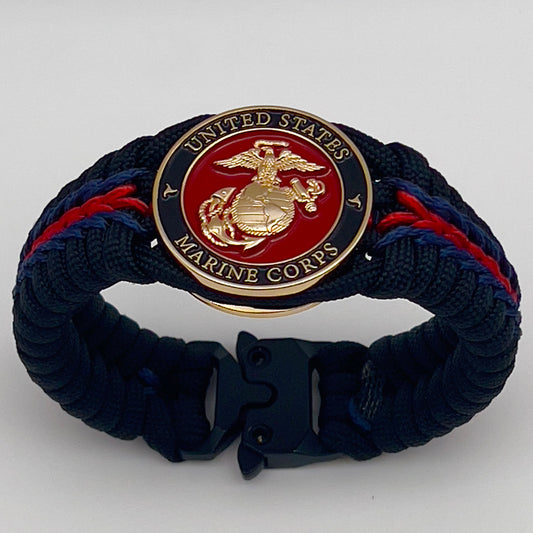 Thick, rigid and comfortable braided United States Marine Corps bracelet featuring a 24K gold plated USMC officer Eagle Globe and Anchor medallion, a black Cobra style tactical buckle and woven with black 550, Imperial red and Navy Blue micro paracord.
