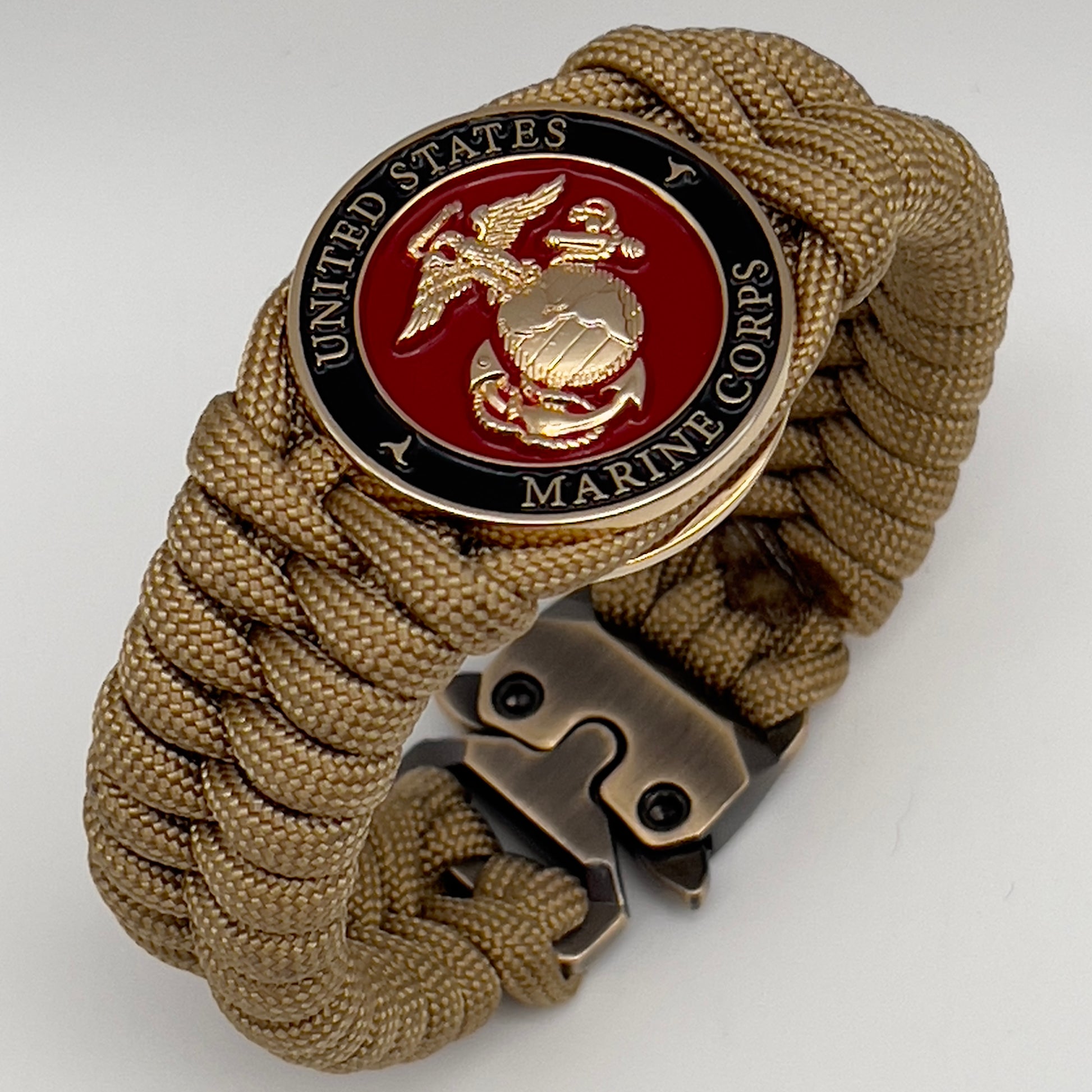 Thick, semi-rigid and comfortable braided United States Marine Corps bracelet featuring a 24K gold plated USMC officer Eagle Globe and Anchor medallion, a gold Cobra style tactical buckle and woven with gold 550 paracord.