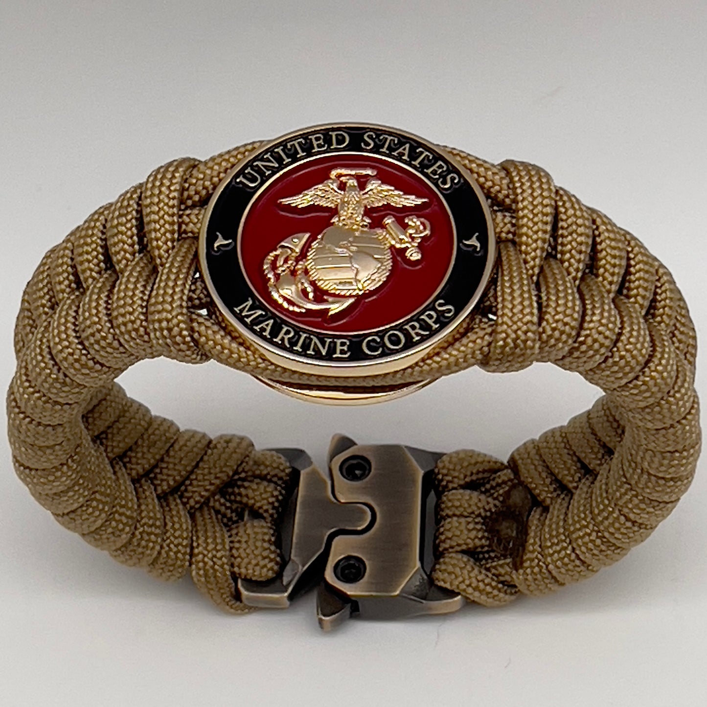 Thick, semi-rigid and comfortable braided United States Marine Corps bracelet featuring a 24K gold plated USMC officer Eagle Globe and Anchor medallion, a gold Cobra style tactical buckle and woven with gold 550 paracord.