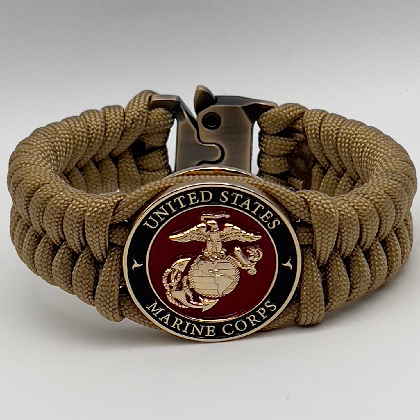 Thick, semi-rigid and comfortable braided United States Marine Corps bracelet featuring a 24K gold plated USMC officer Eagle Globe and Anchor medallion, a gold Cobra style tactical buckle and woven with gold 550 paracord.
