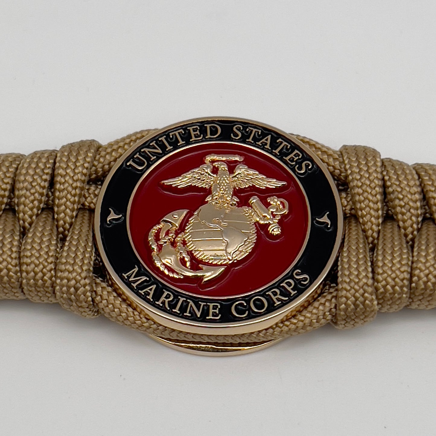 Thick, semi-rigid and comfortable braided United States Marine Corps bracelet featuring a 24K gold plated USMC officer Eagle Globe and Anchor medallion, a gold Cobra style tactical buckle and woven with gold 550 paracord.