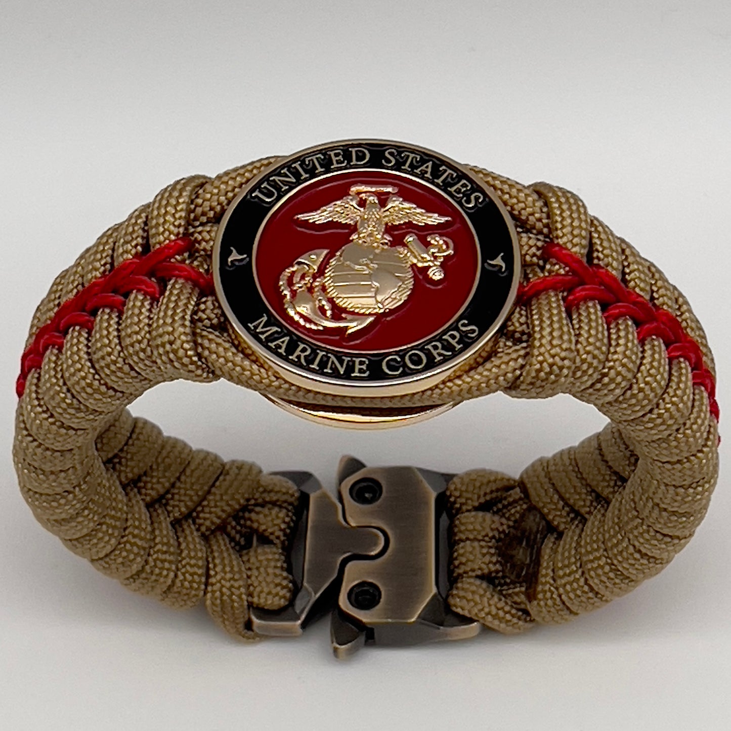 Thick, semi-rigid and comfortable braided United States Marine Corps bracelet featuring a 24K gold plated USMC officer Eagle Globe and Anchor medallion, a gold Cobra style tactical buckle and woven with gold 550 paracord and Imperial Red micro cord.