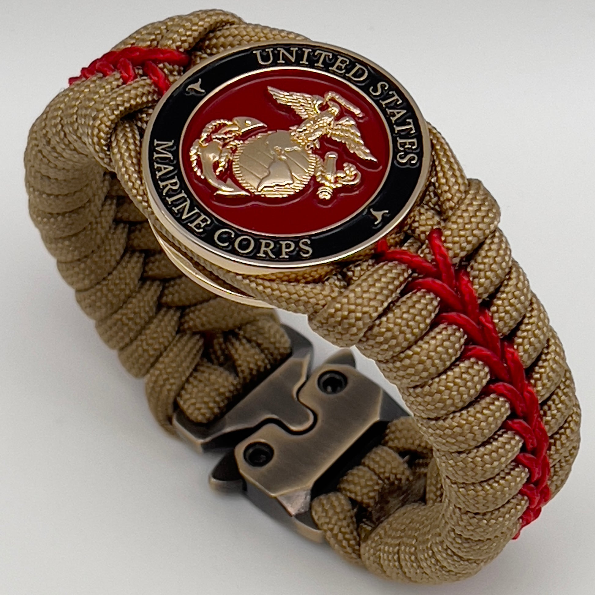 Thick, semi-rigid and comfortable braided United States Marine Corps bracelet featuring a 24K gold plated USMC officer Eagle Globe and Anchor medallion, a gold Cobra style tactical buckle and woven with gold 550 paracord and Imperial Red micro cord.