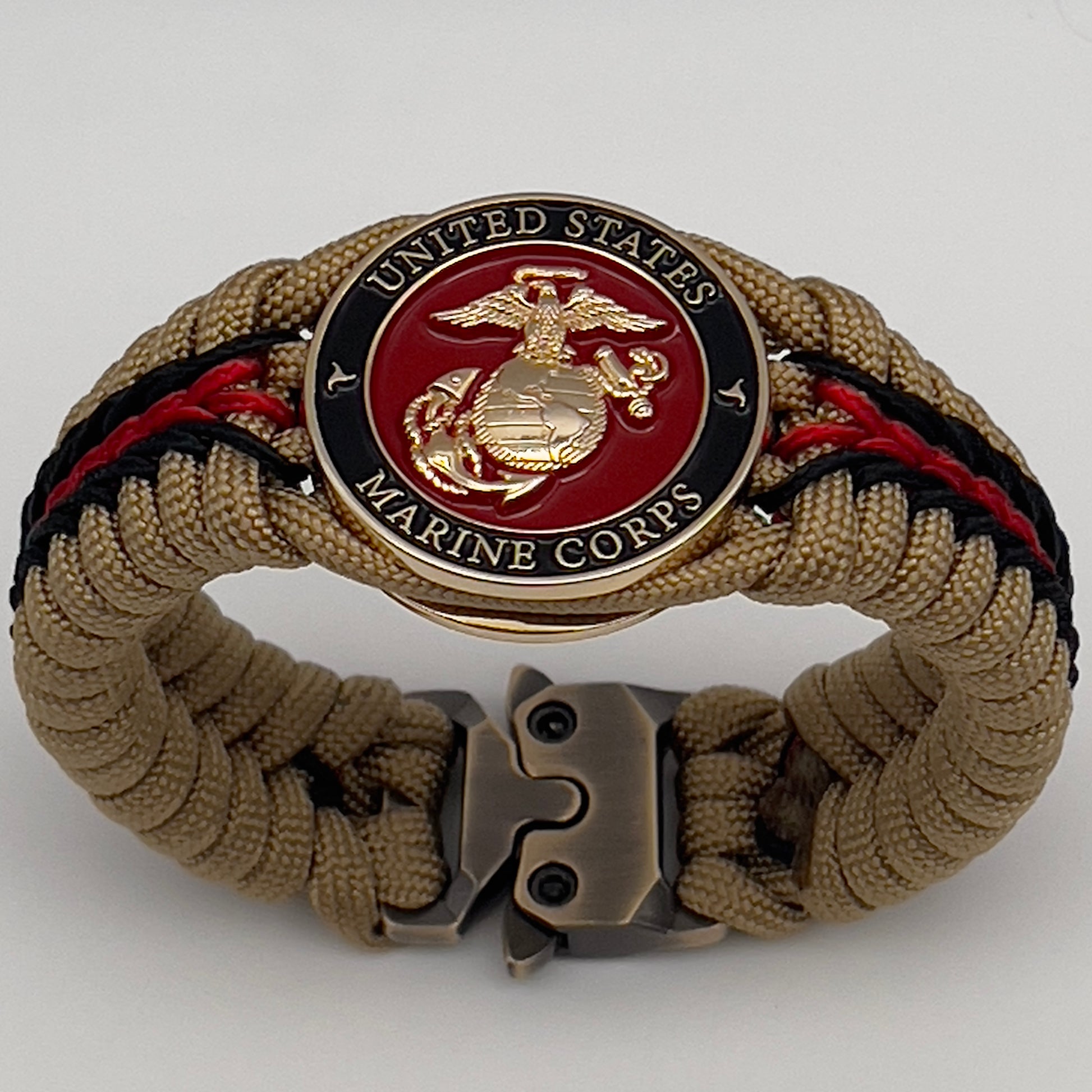 Thick, rigid and comfortable braided United States Marine Corps bracelet featuring a 24K gold plated USMC officer Eagle Globe and Anchor medallion, a gold Cobra style tactical buckle and woven with gold 550 paracord and Imperial Red and black micro cord.