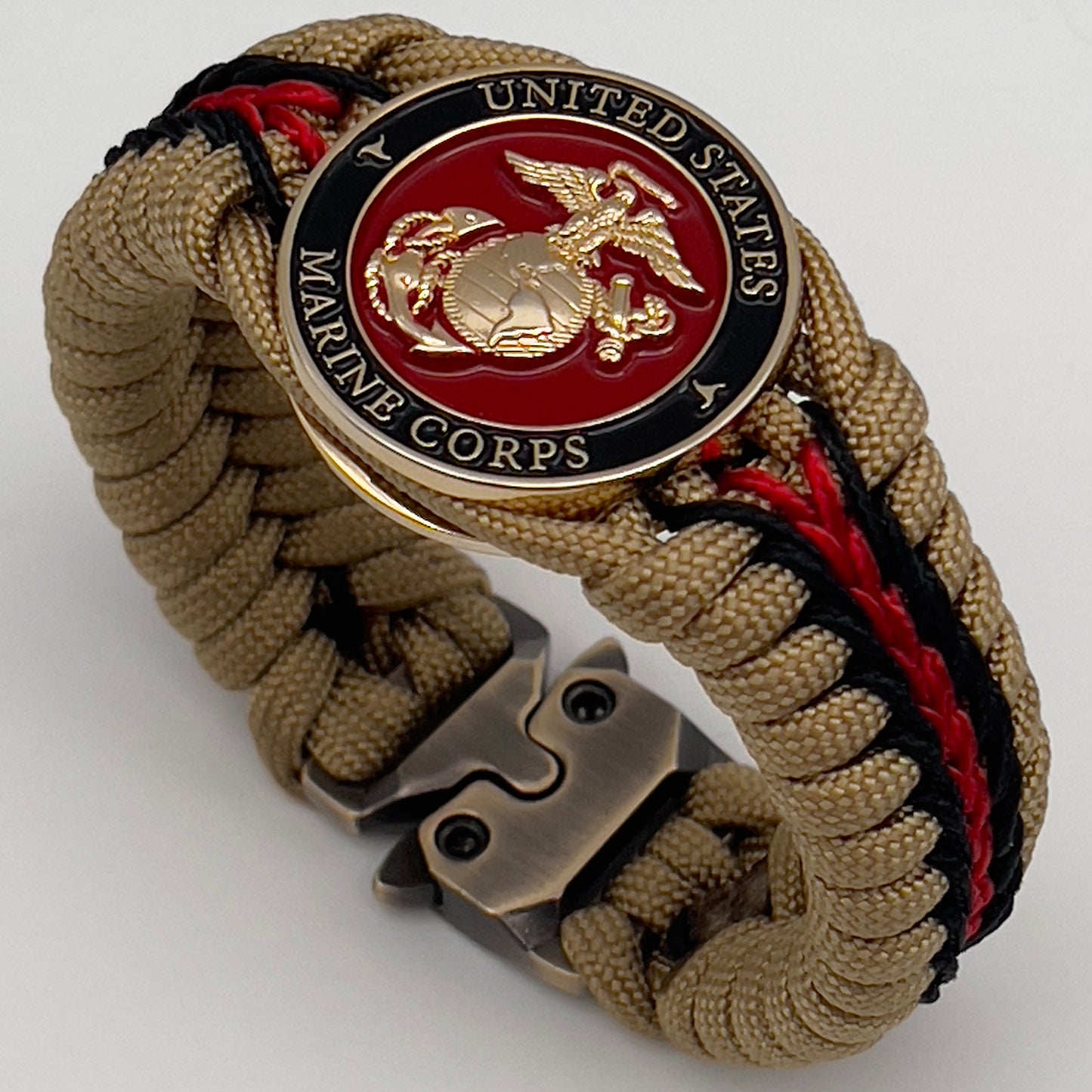 Thick, rigid and comfortable braided United States Marine Corps bracelet featuring a 24K gold plated USMC officer Eagle Globe and Anchor medallion, a gold Cobra style tactical buckle and woven with gold 550 paracord and Imperial Red and black micro cord.