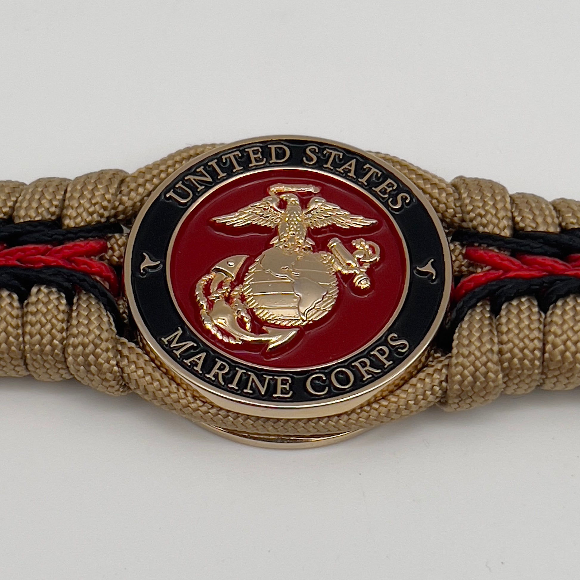 Thick, rigid and comfortable braided United States Marine Corps bracelet featuring a 24K gold plated USMC officer Eagle Globe and Anchor medallion, a gold Cobra style tactical buckle and woven with gold 550 paracord and Imperial Red and black micro cord.