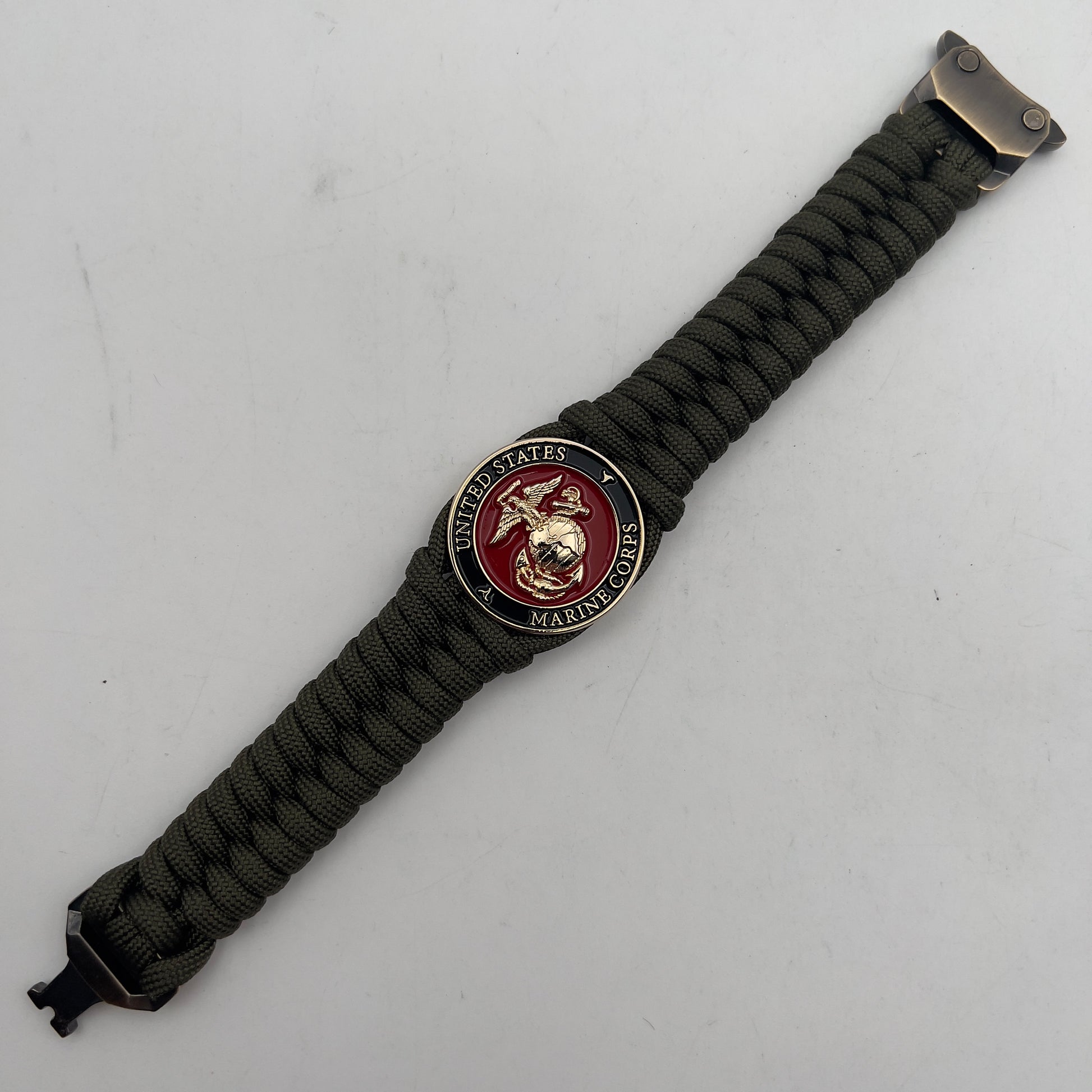Thick, semi-rigid and comfortable braided United States Marine Corps bracelet featuring a 24K gold plated USMC officer Eagle Globe and Anchor medallion, a gold Cobra style tactical buckle and woven with olive drab 550 paracord.