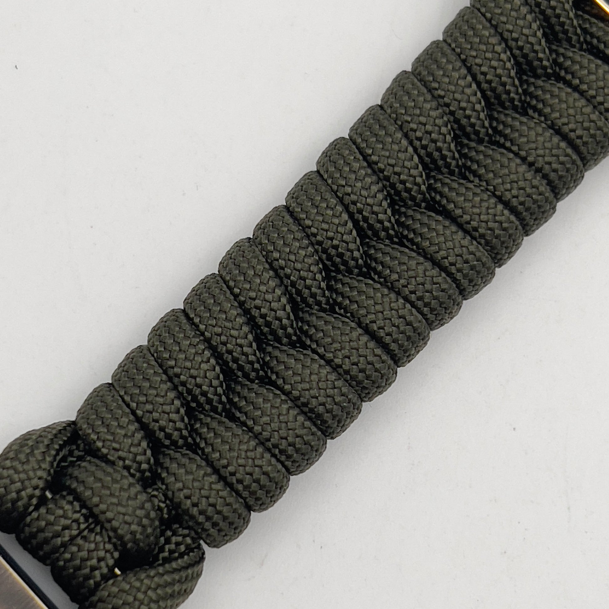 Thick, semi-rigid and comfortable braided United States Marine Corps bracelet featuring a 24K gold plated USMC officer Eagle Globe and Anchor medallion, a gold Cobra style tactical buckle and woven with olive drab 550 paracord.
