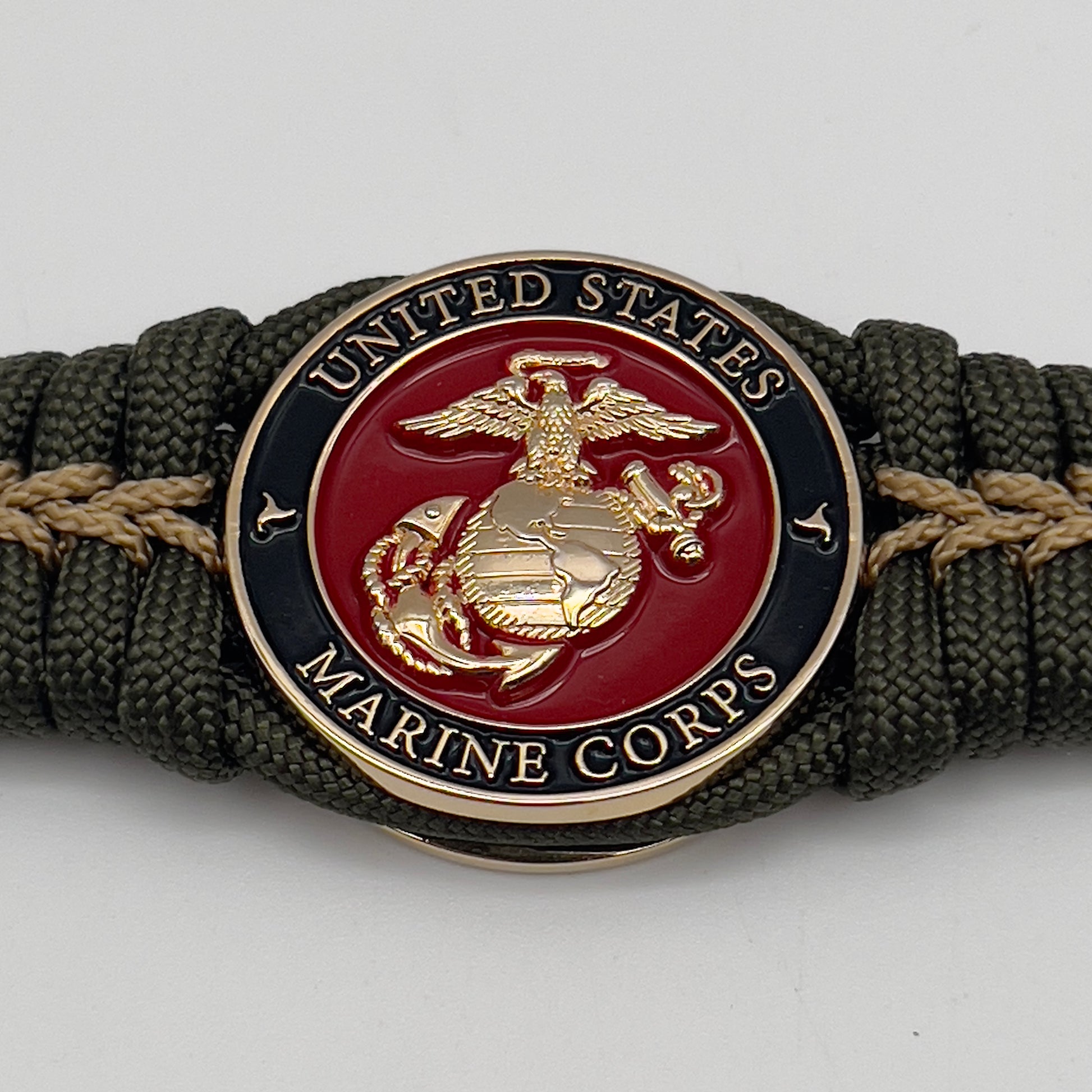 Thick, semi-rigid and comfortable braided United States Marine Corps bracelet featuring a 24K gold plated USMC officer Eagle Globe and Anchor medallion, a gold Cobra style tactical buckle and woven with olive drab 550 paracord and gold micro cord.