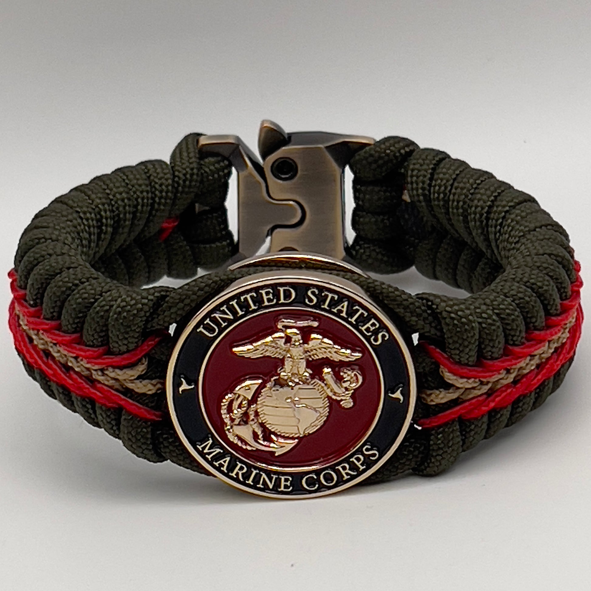 Thick, rigid and comfortable braided United States Marine Corps bracelet featuring a 24K gold plated USMC officer Eagle Globe and Anchor medallion, a gold Cobra style tactical buckle and woven with olive drab 550 paracord and Imperial Red and gold micro cord.
