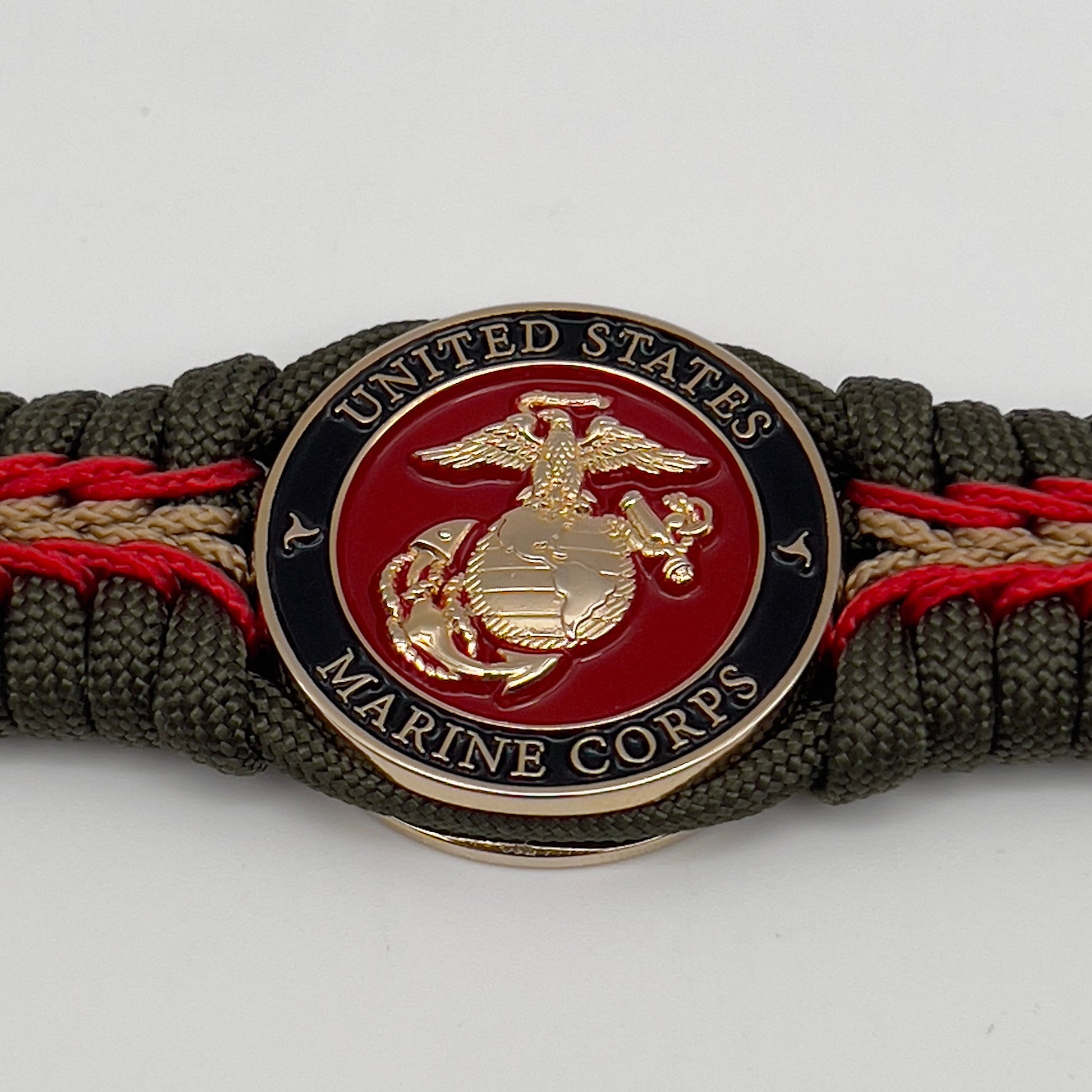 Thick, rigid and comfortable braided United States Marine Corps bracelet featuring a 24K gold plated USMC officer Eagle Globe and Anchor medallion, a gold Cobra style tactical buckle and woven with olive drab 550 paracord and Imperial Red and gold micro cord.