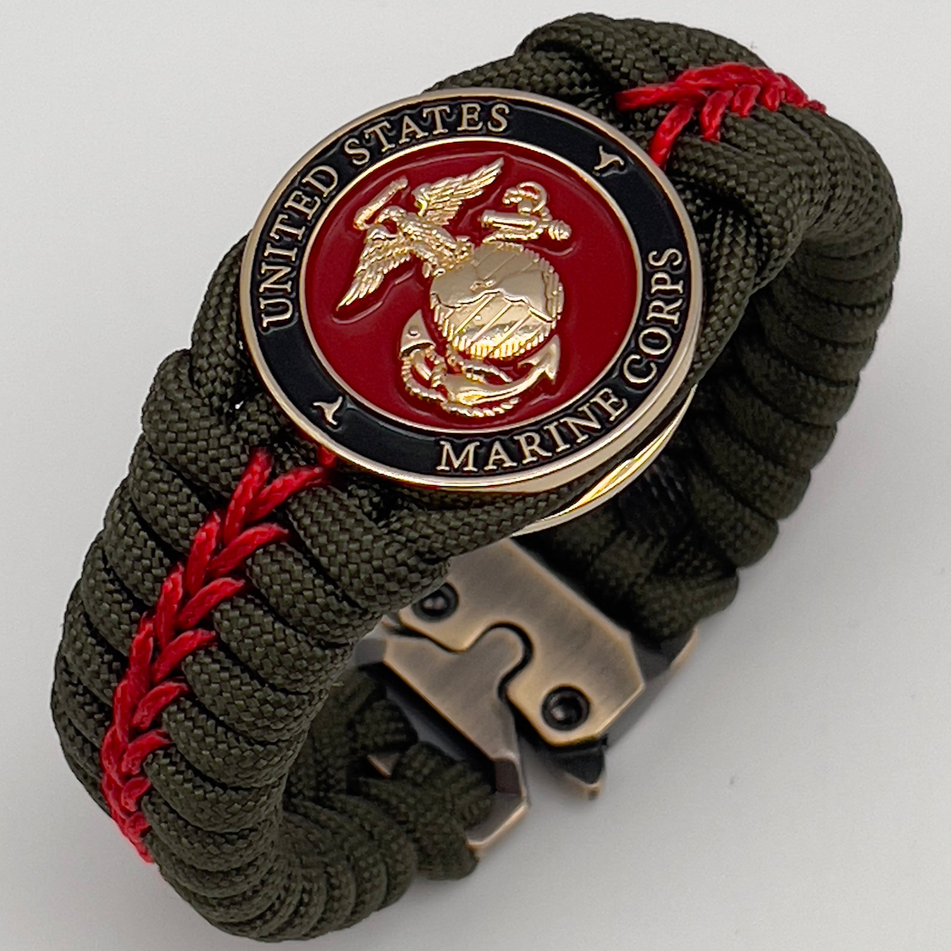 Thick, semi-rigid and comfortable braided United States Marine Corps bracelet featuring a 24K gold plated USMC officer Eagle Globe and Anchor medallion, a gold Cobra style tactical buckle and woven with olive drab 550 paracord and Imperial Red micro cord.